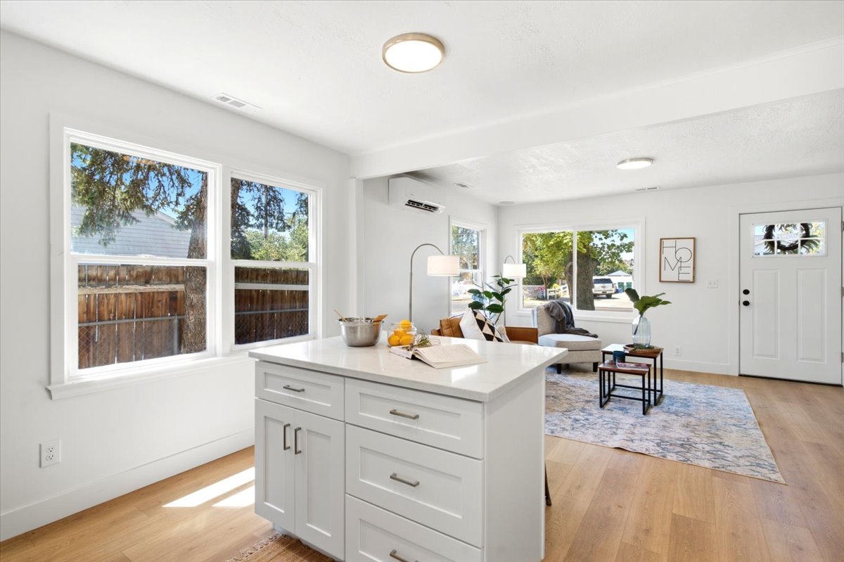 Kitchen island featuring white cabinetry with silver hardware, and a light-toned countertop