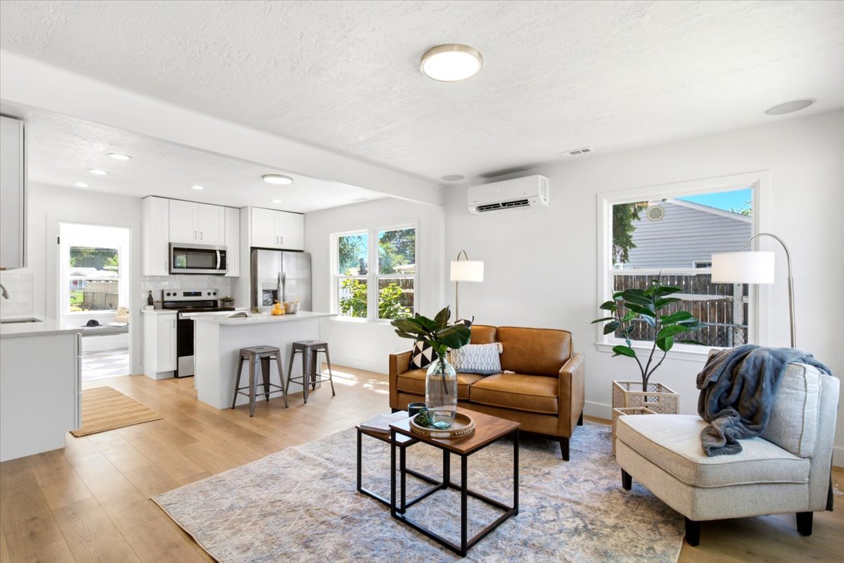 Open-concept living area featuring light wood-finish flooring, white walls, and recessed lighting