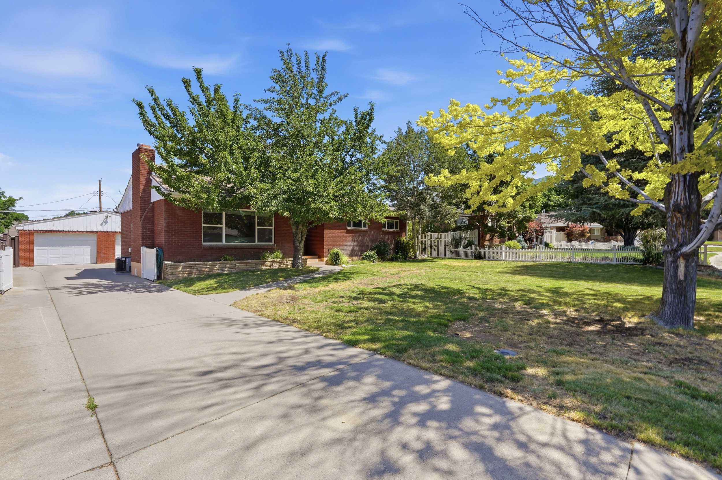 Brick residence featuring a wide concrete driveway and an attached garage with a white door