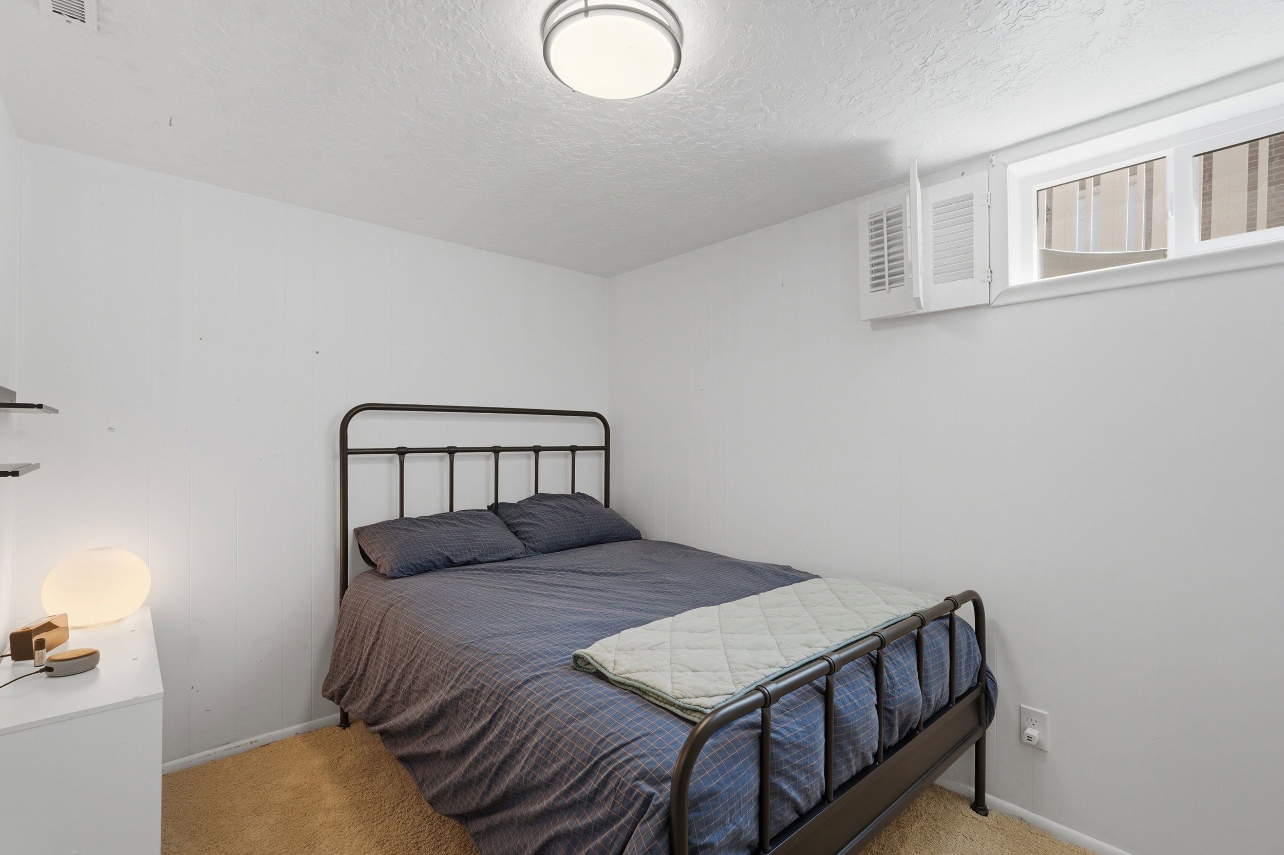 White-painted room featuring a window with white trim, a flush-mount ceiling light fixture, and light brown carpet flooring