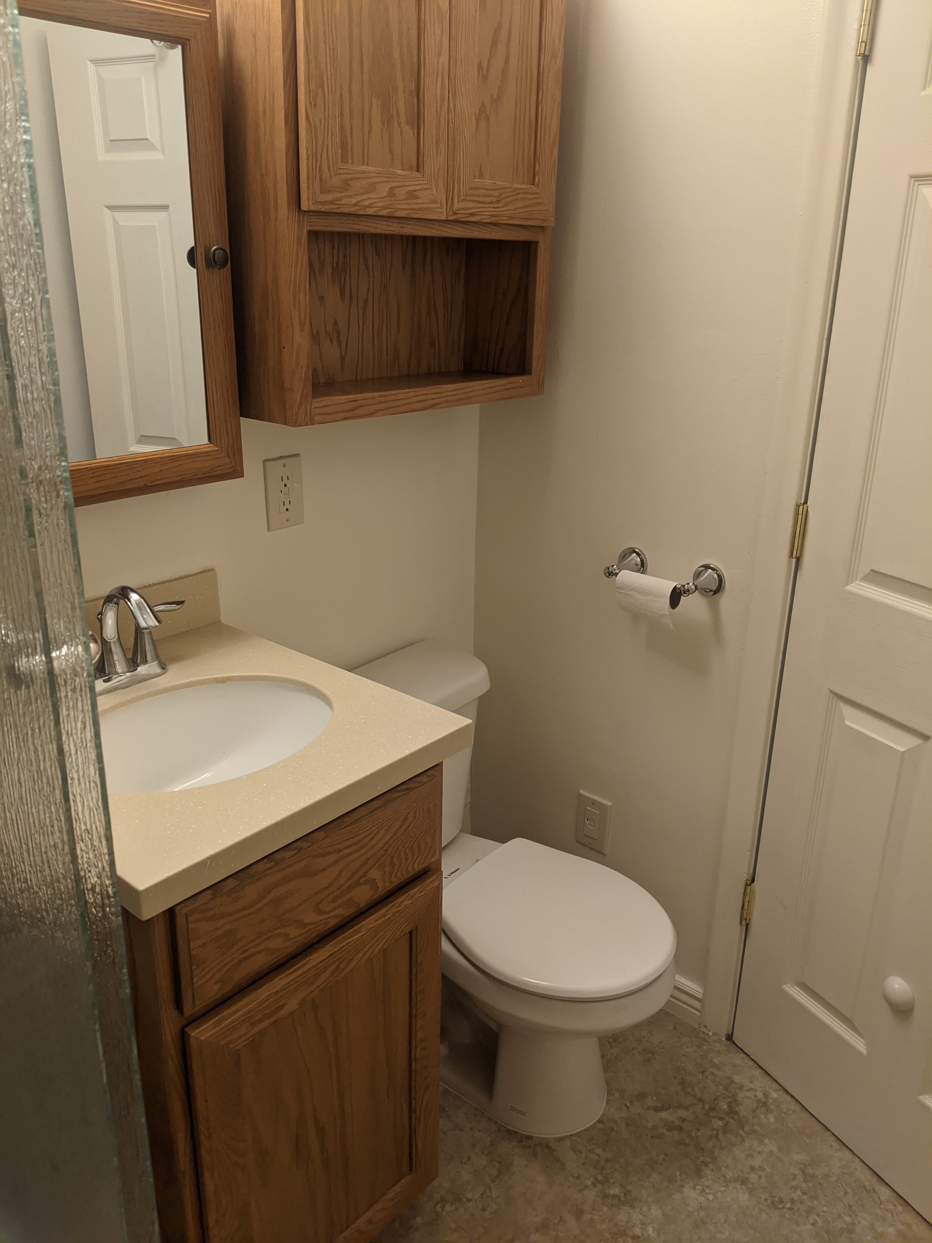 Bathroom featuring a single vanity with a countertop, an integrated sink, and wood-finish cabinetry