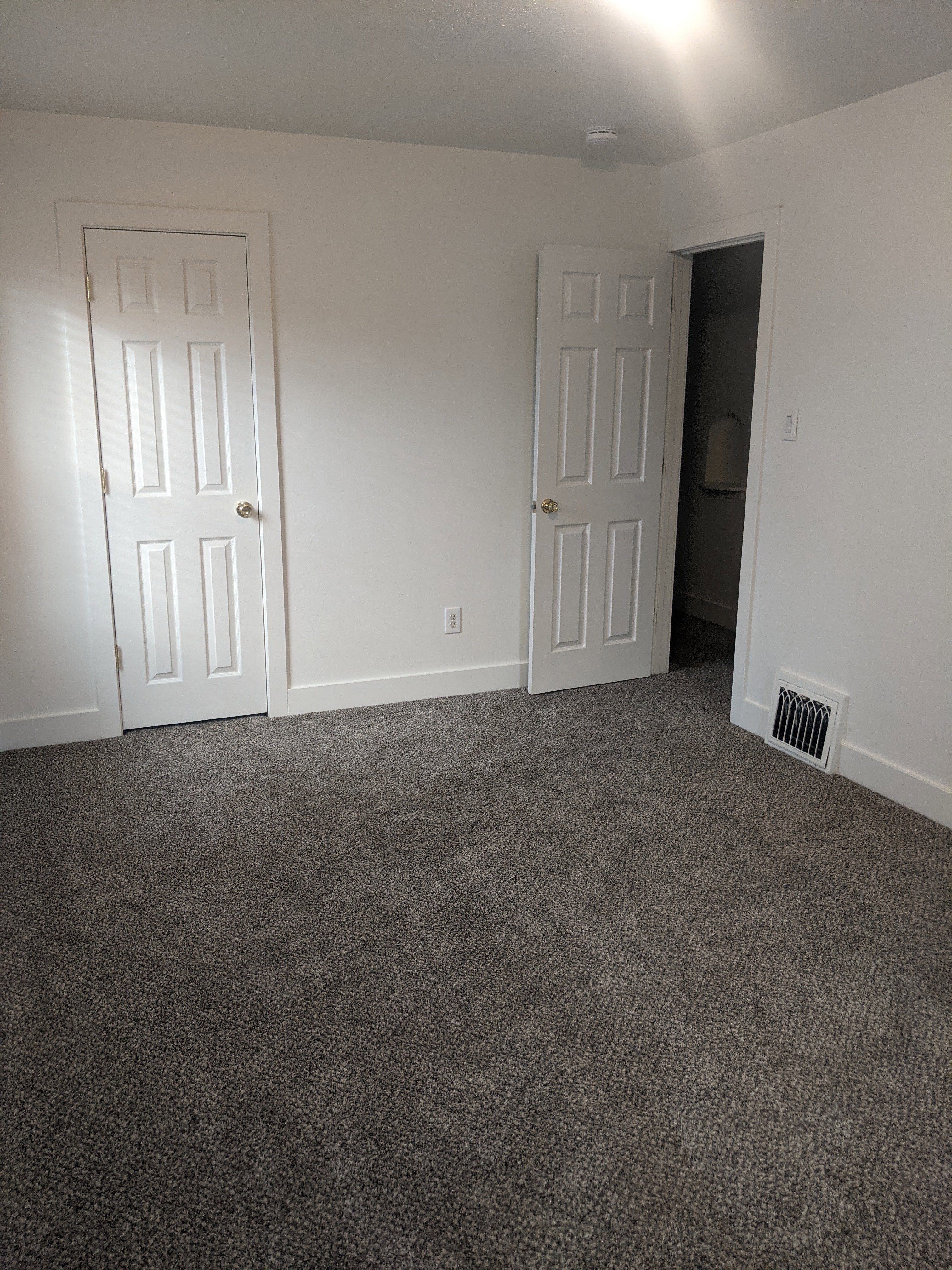 Spacious interior featuring neutral carpeting and crisp white walls