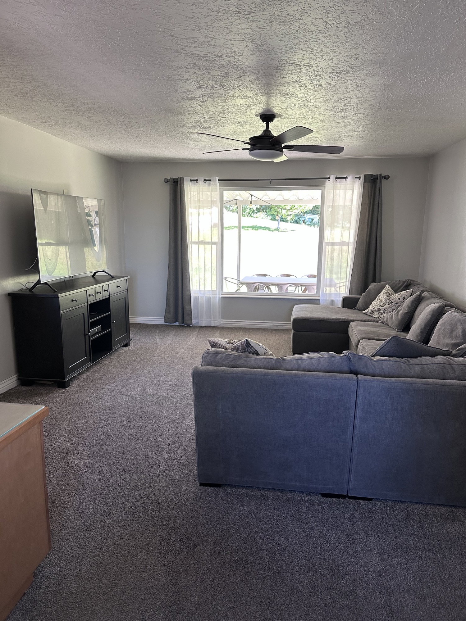 Spacious living area featuring neutral carpeting and light gray walls