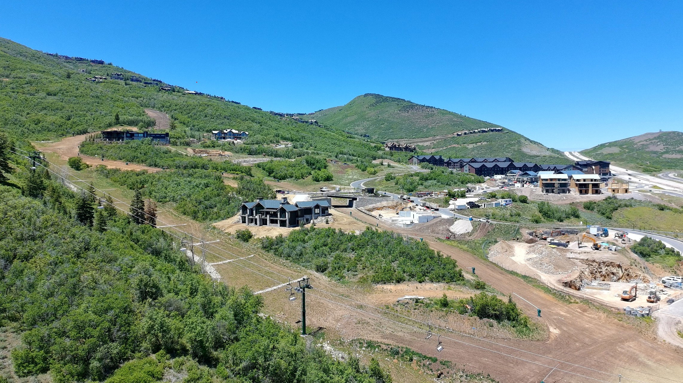 Expansive mountain landscape featuring varied terrain and multiple properties under construction
