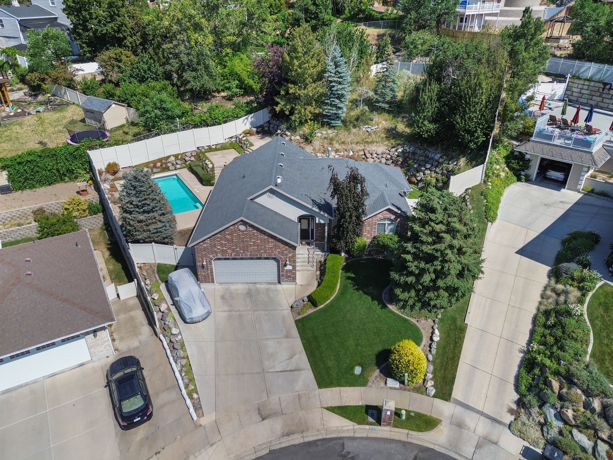 Brick-clad residence featuring a dark shingle roof, attached two-car garage, and a concrete driveway
