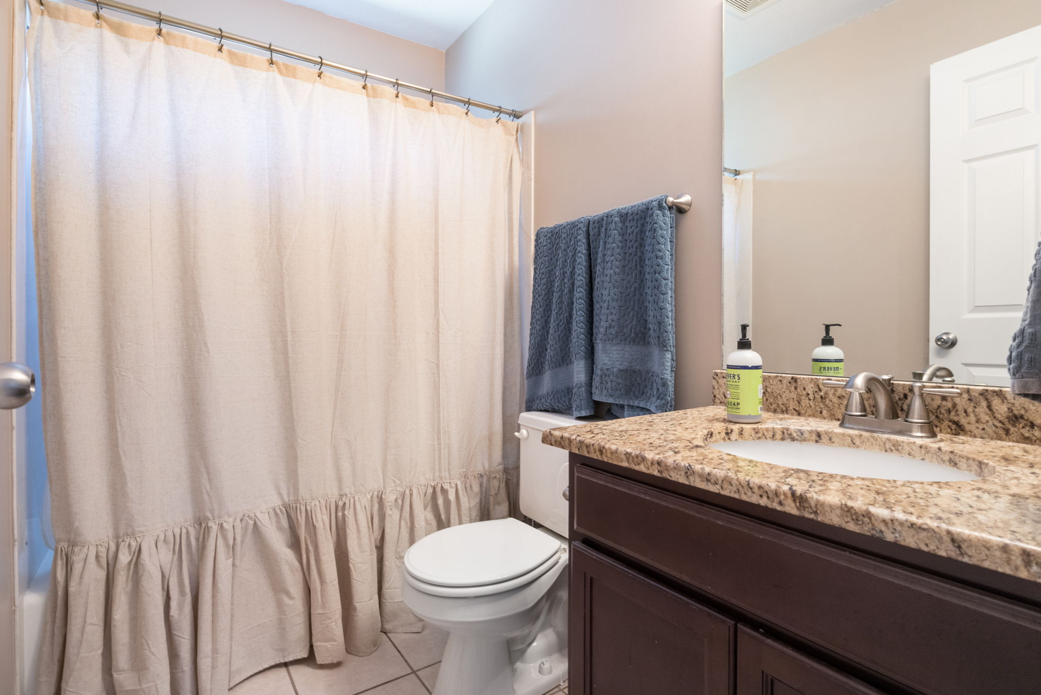Bathroom featuring a vanity with a stone countertop, an undermount sink, and a brushed nickel faucet