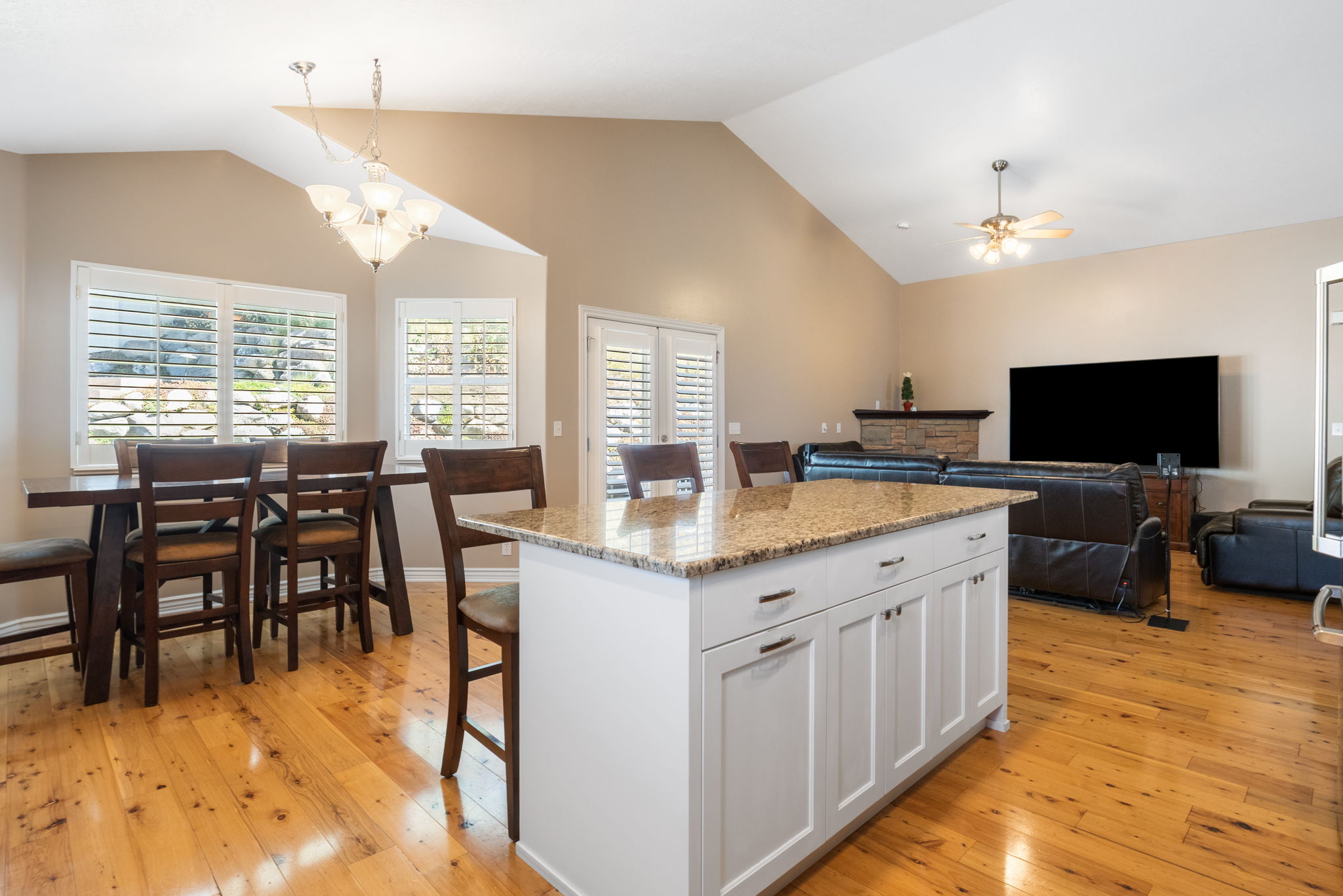 Kitchen island with granite countertop and white cabinetry