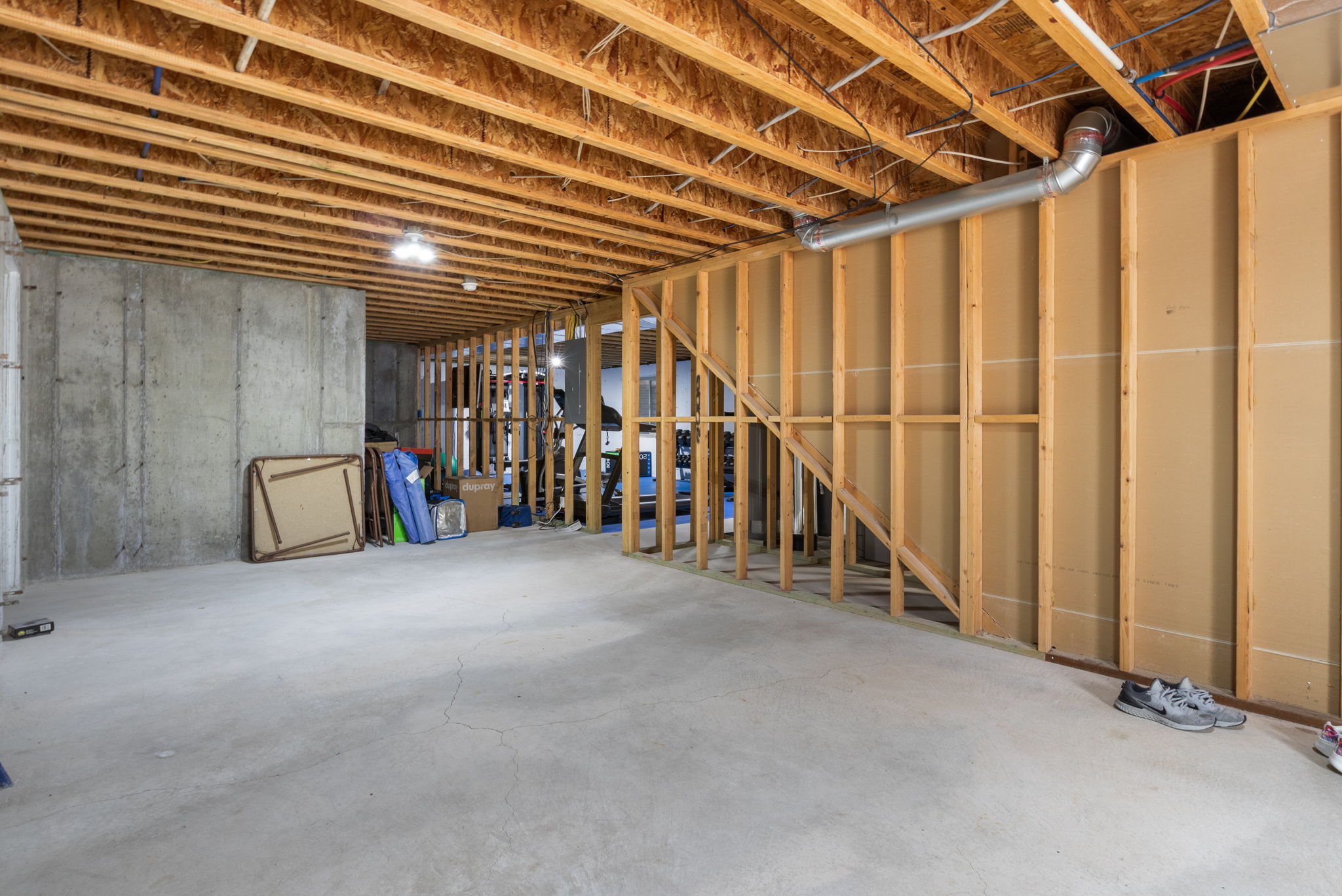 Unfinished basement featuring concrete flooring and exposed ceiling joists