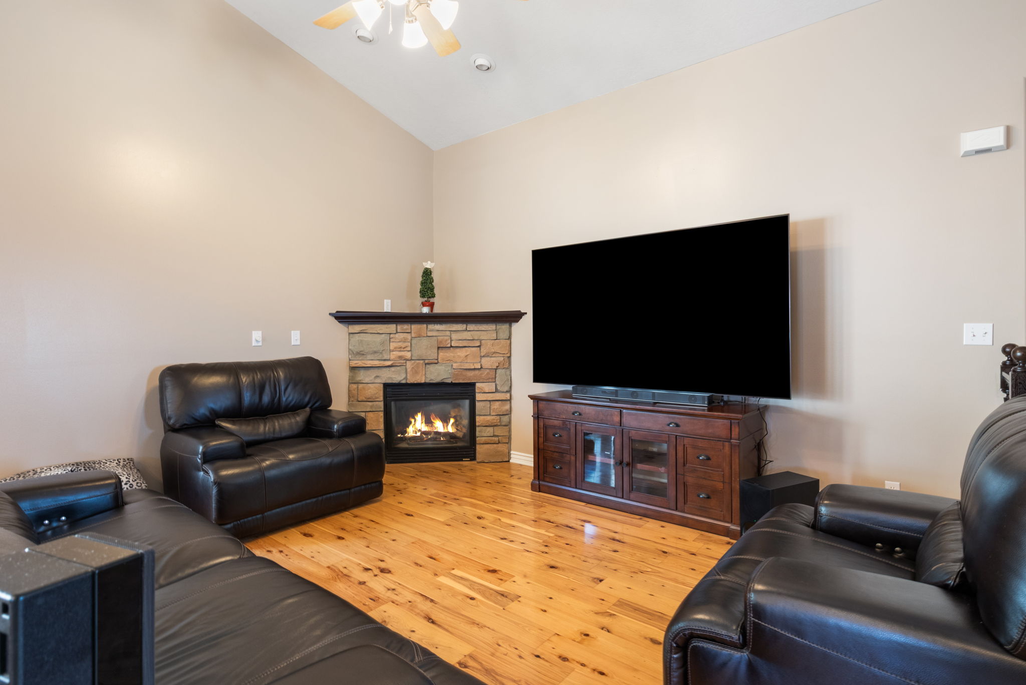 Living area with vaulted ceiling and light wood-finish flooring