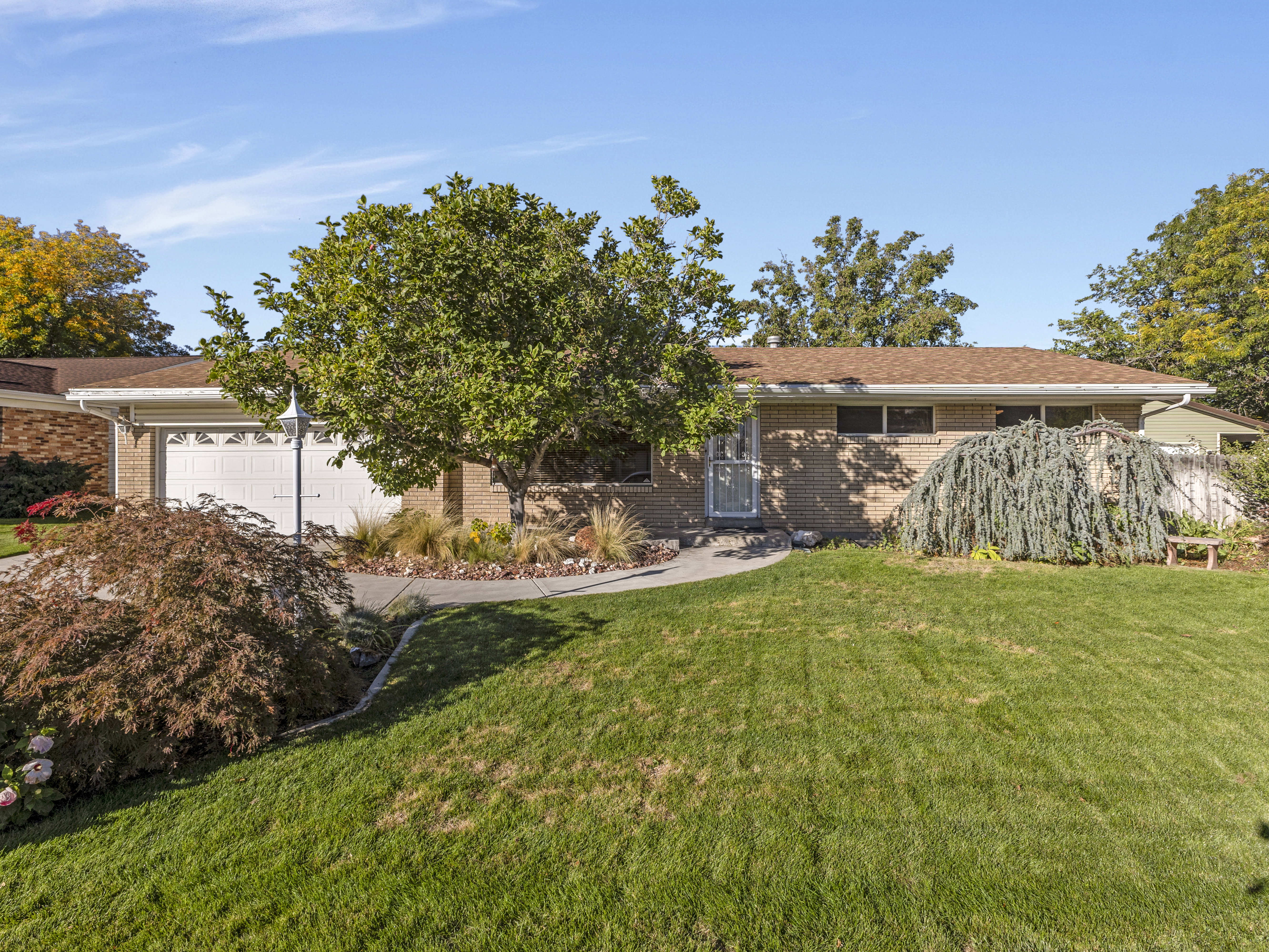Brick exterior with an attached garage, featuring a brown shingle roof