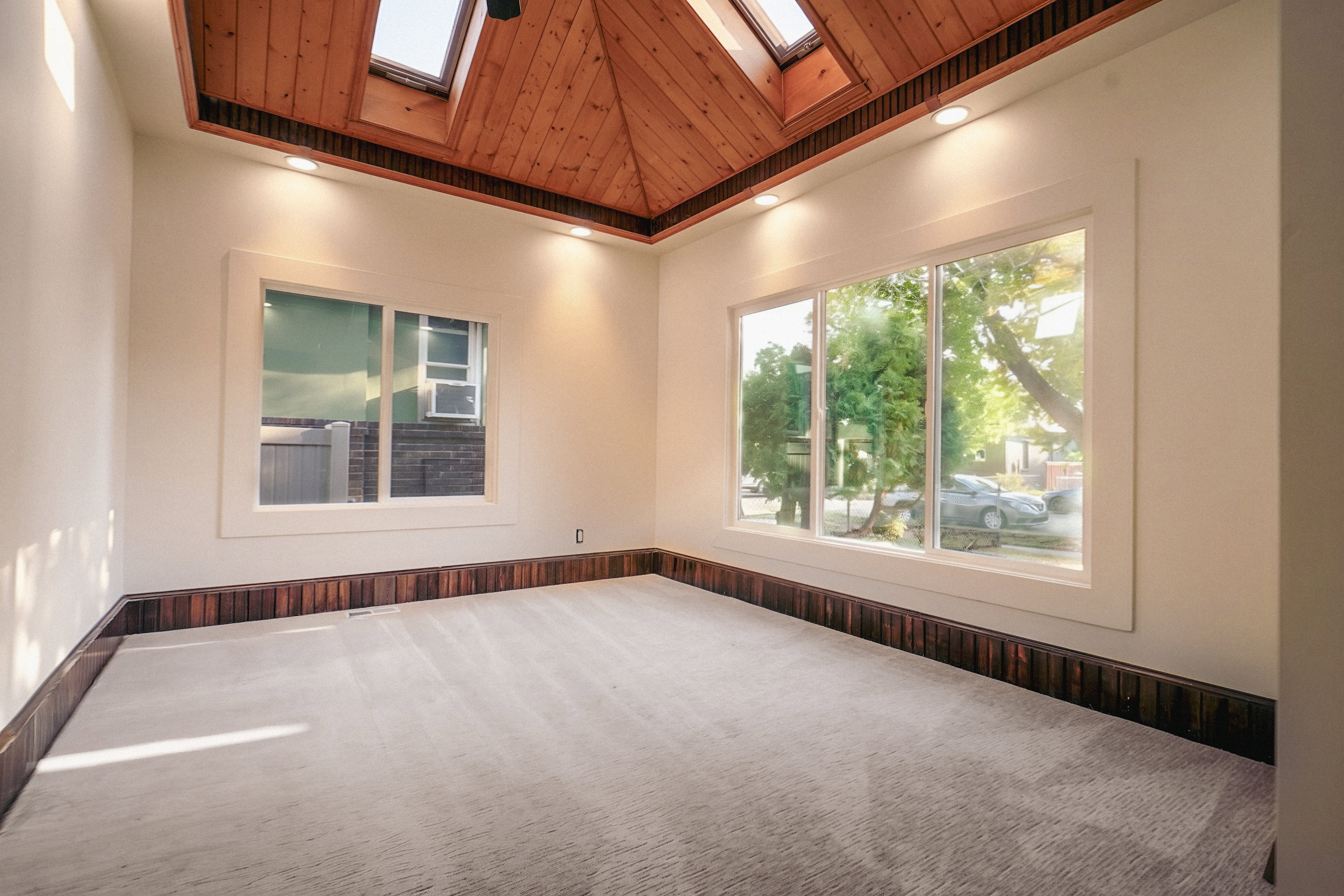 Vaulted wood-paneled ceiling with skylights and recessed lighting