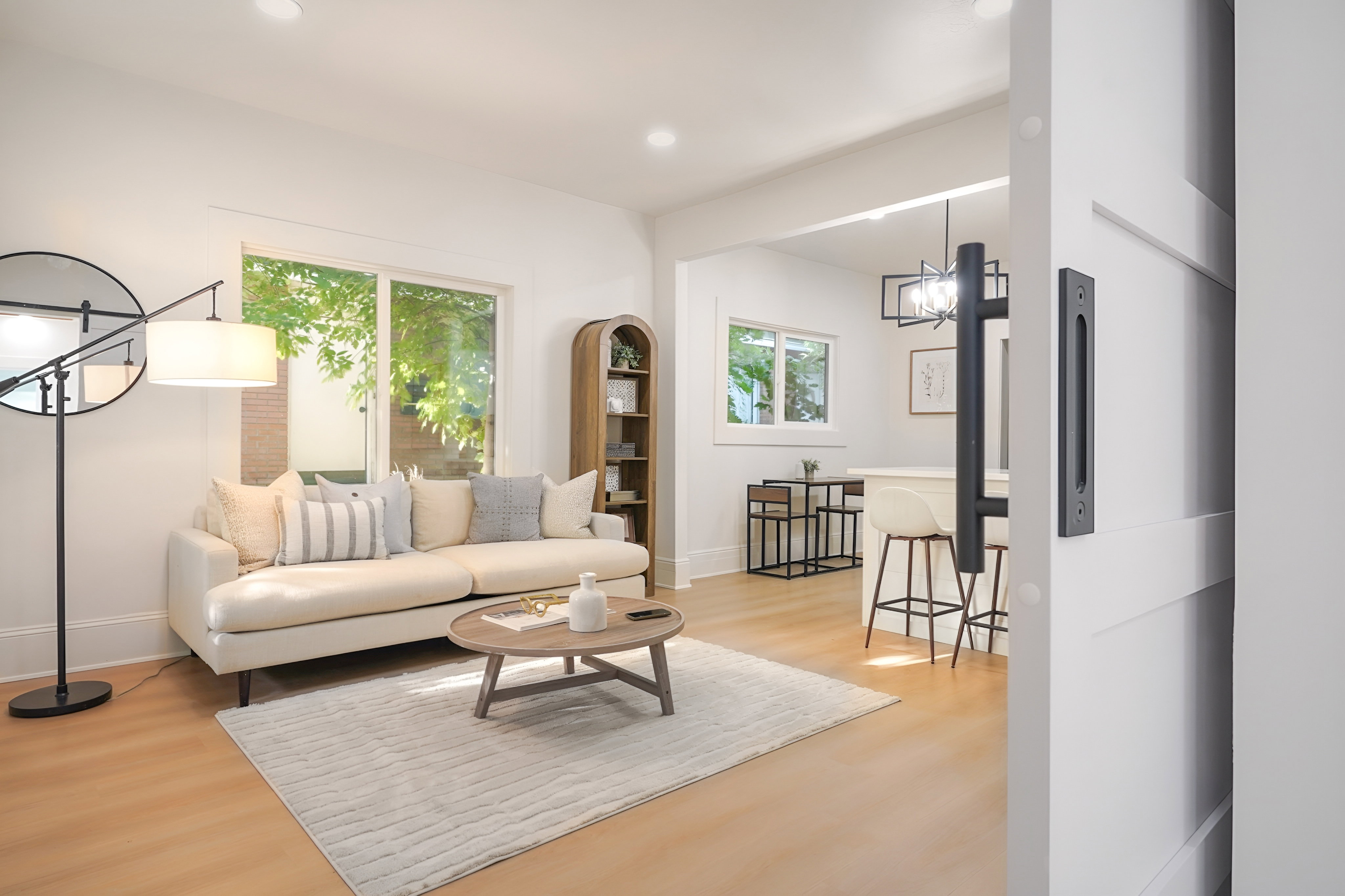 Living area with light wood-finish flooring and recessed lighting