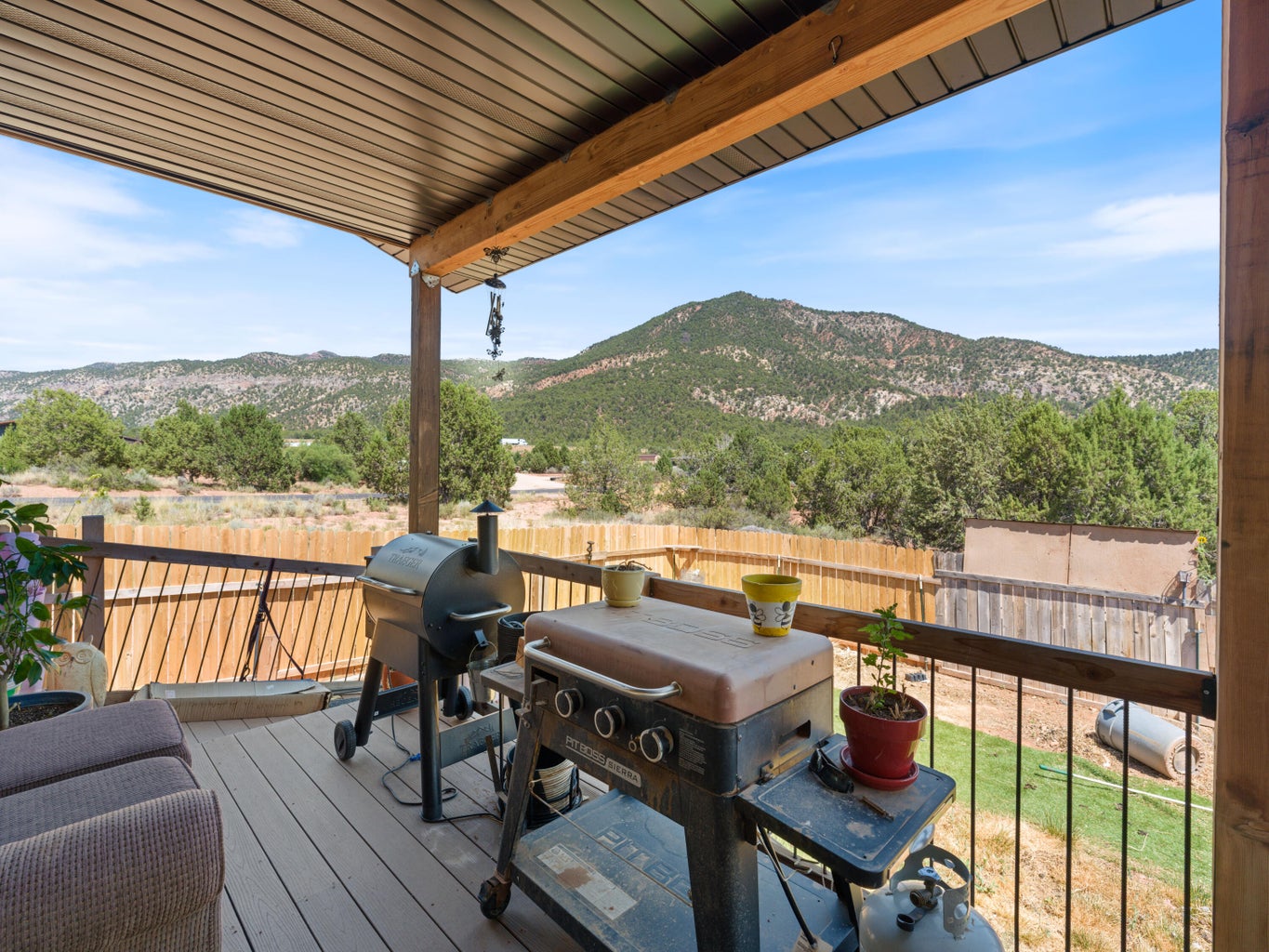 Covered outdoor deck with wood-finish flooring and black metal railing