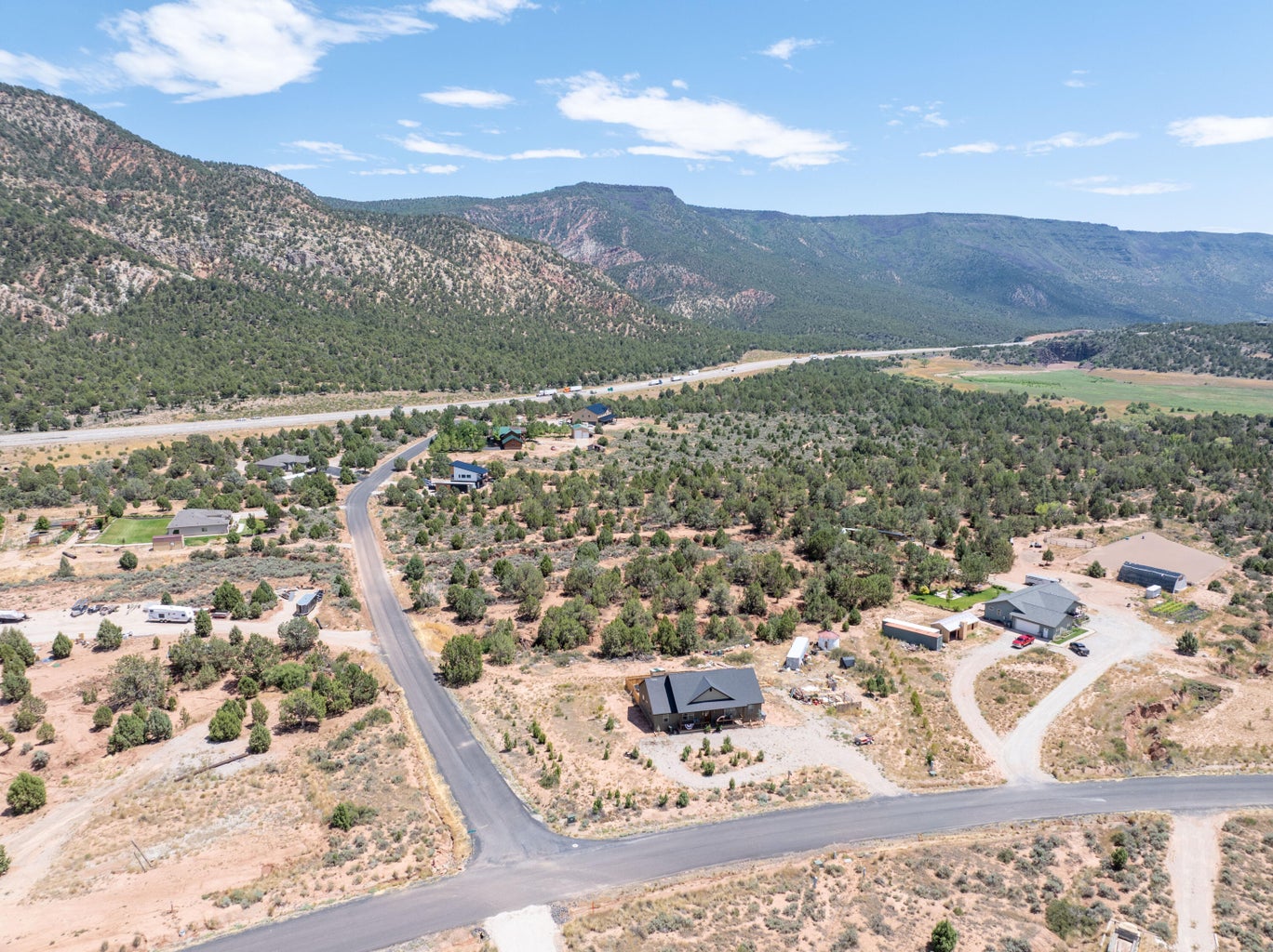 Aerial view showcasing a residential area with varied home styles, surrounded by natural desert landscaping and distant mountains