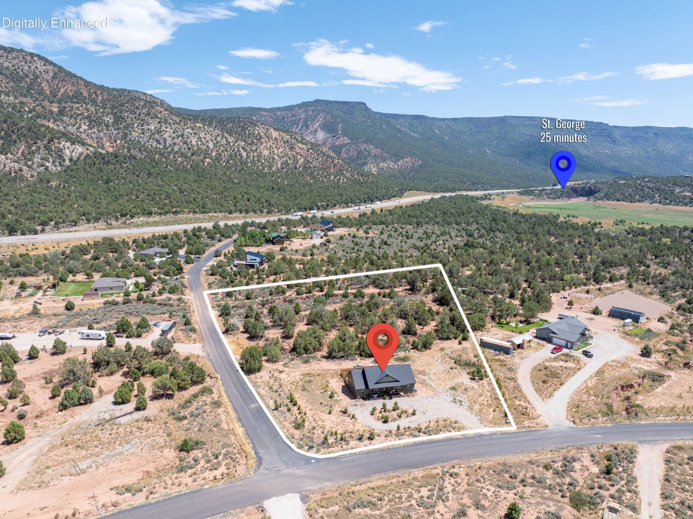 Aerial view showcasing a modern black-roofed residence nestled within a natural, arid landscape