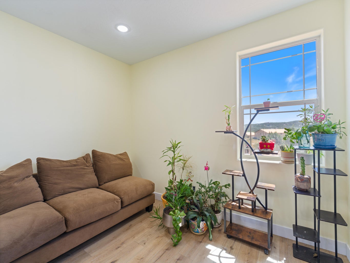 Bright room featuring a large window, recessed lighting, and wood-finish flooring