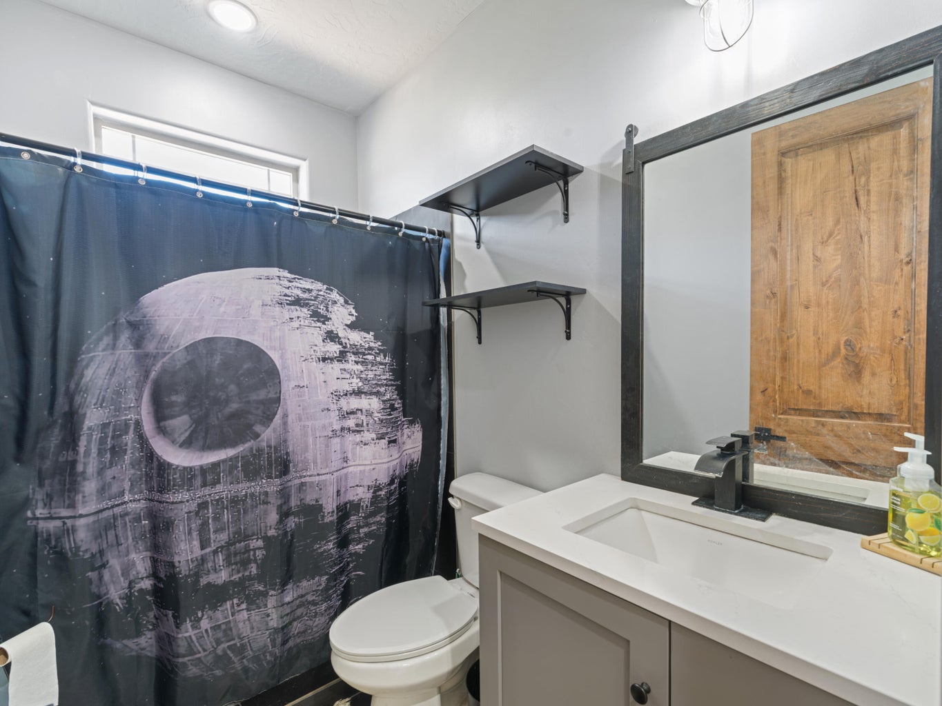 Bathroom featuring a light gray vanity with a white countertop and integrated sink