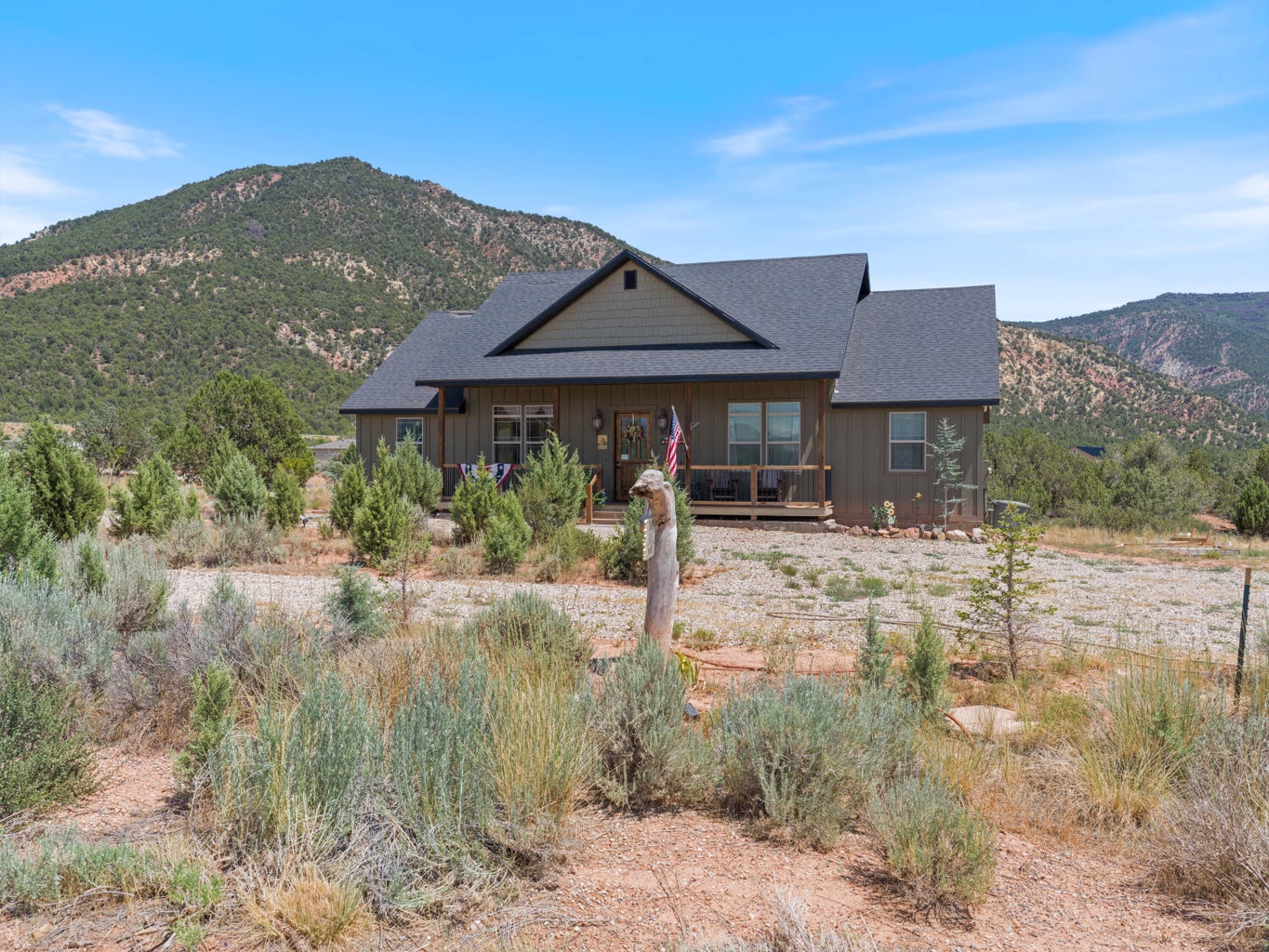 Contemporary residence featuring vertical plank siding and a covered front porch