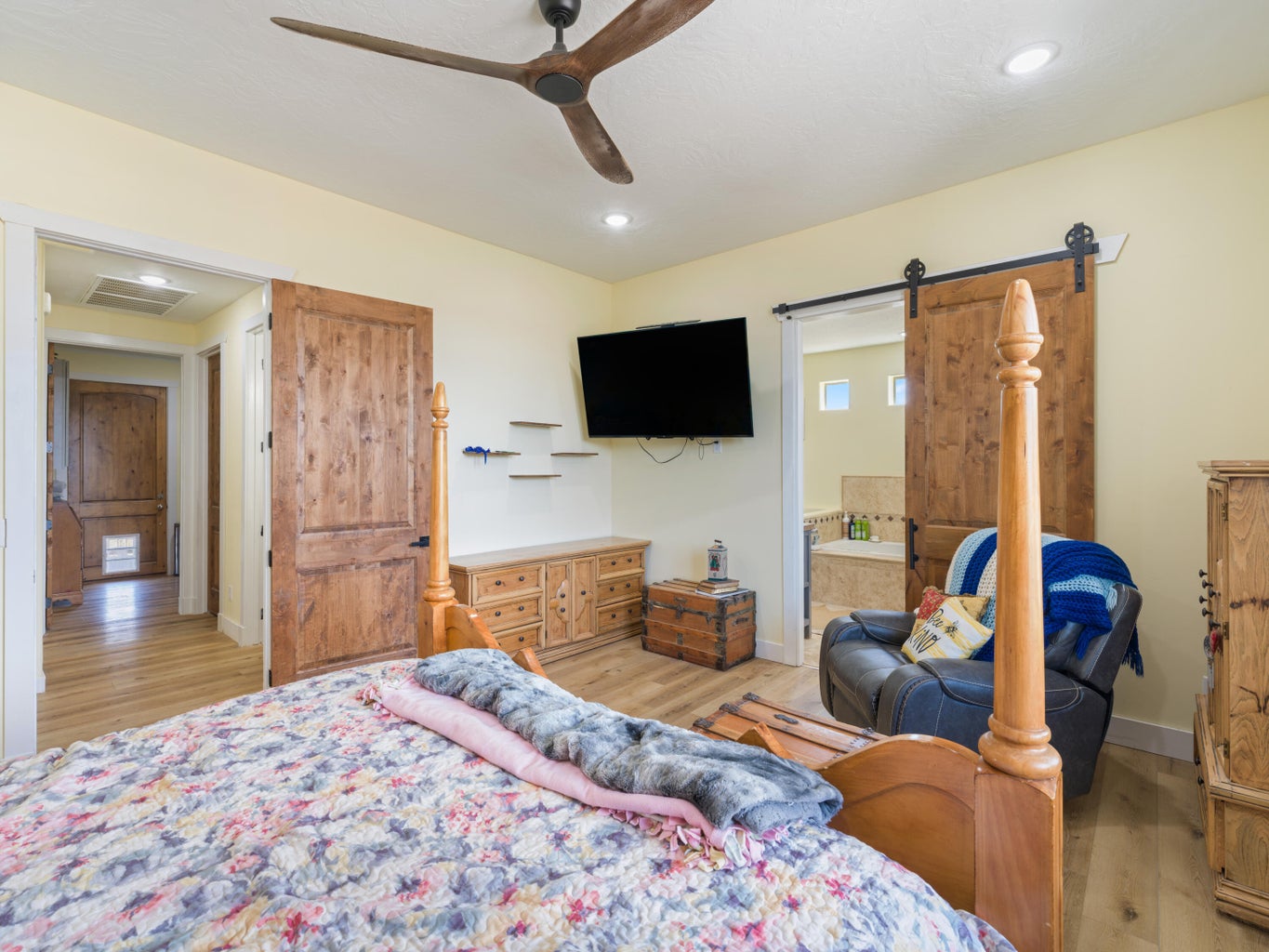 Spacious room featuring wood-finish flooring, a contemporary ceiling fan, and recessed lighting