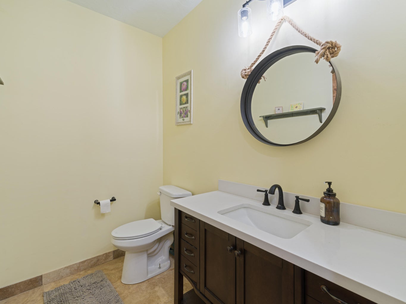 Bathroom featuring a dark wood-finish vanity with a white countertop and integrated sink