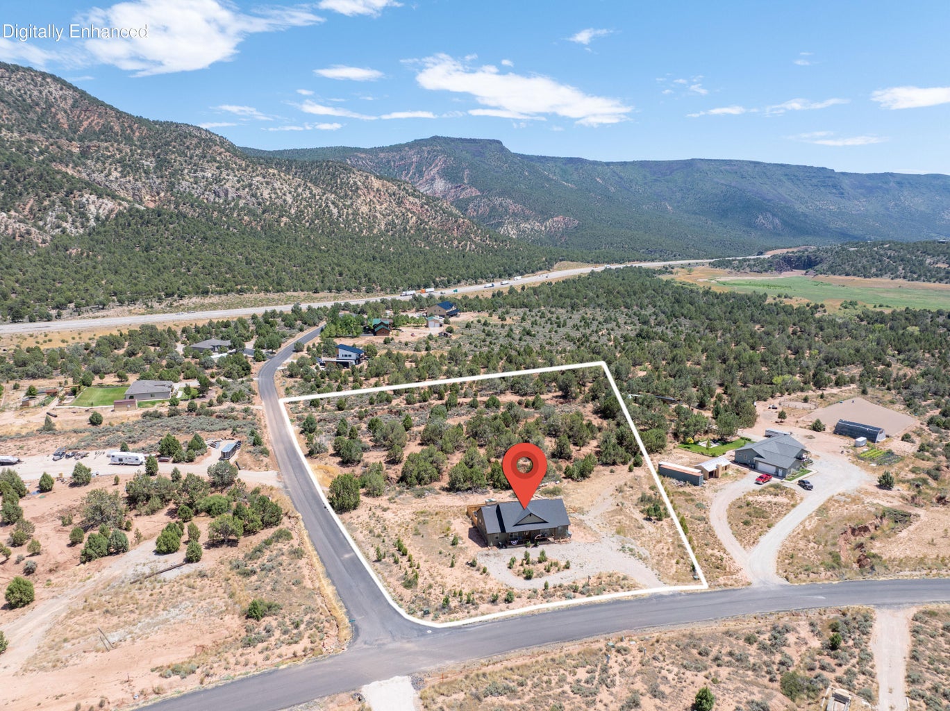 Aerial depiction of a property featuring a single-story dwelling with a dark-pitched roof, set on a winding paved road