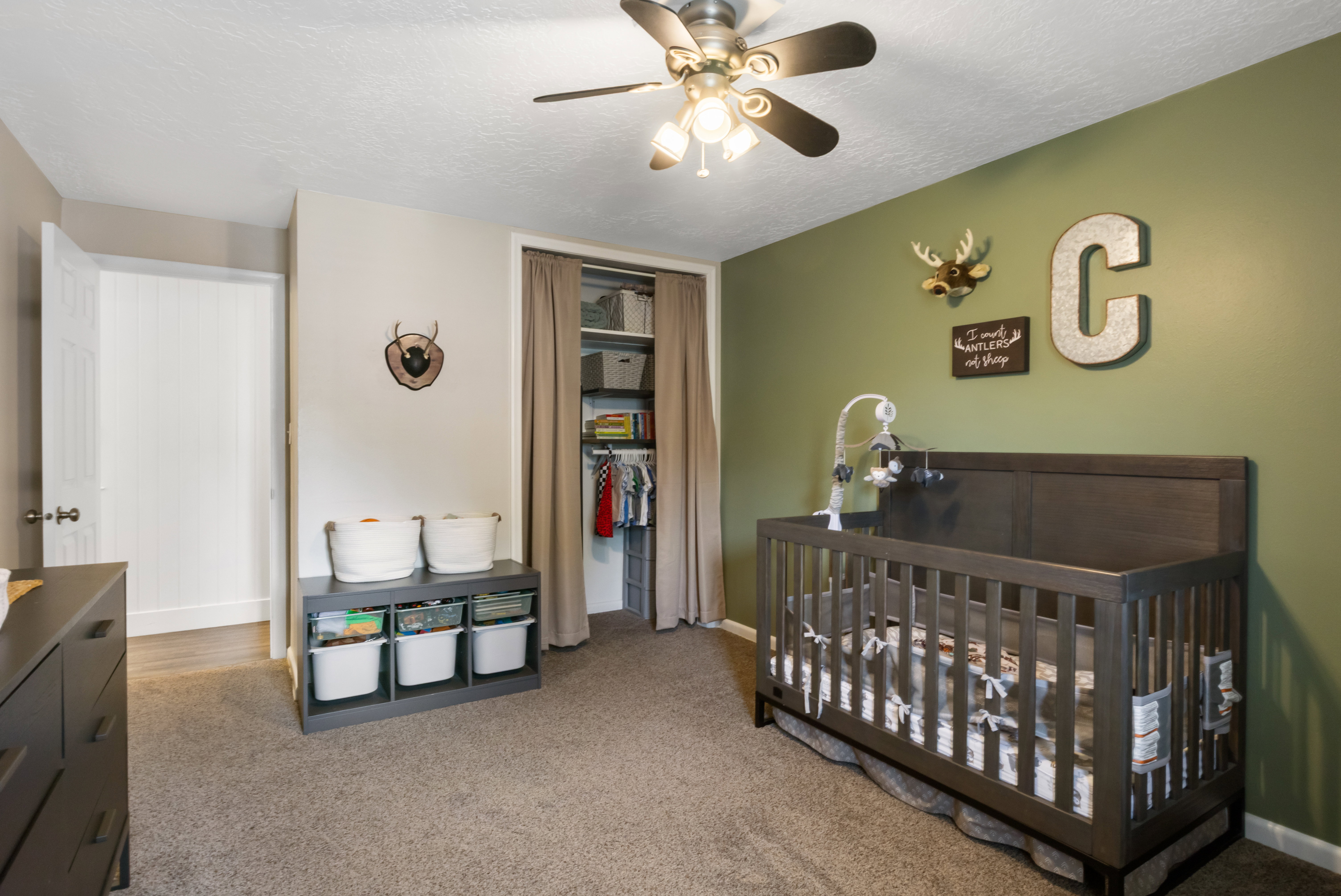 Carpeted room with a ceiling fan light fixture