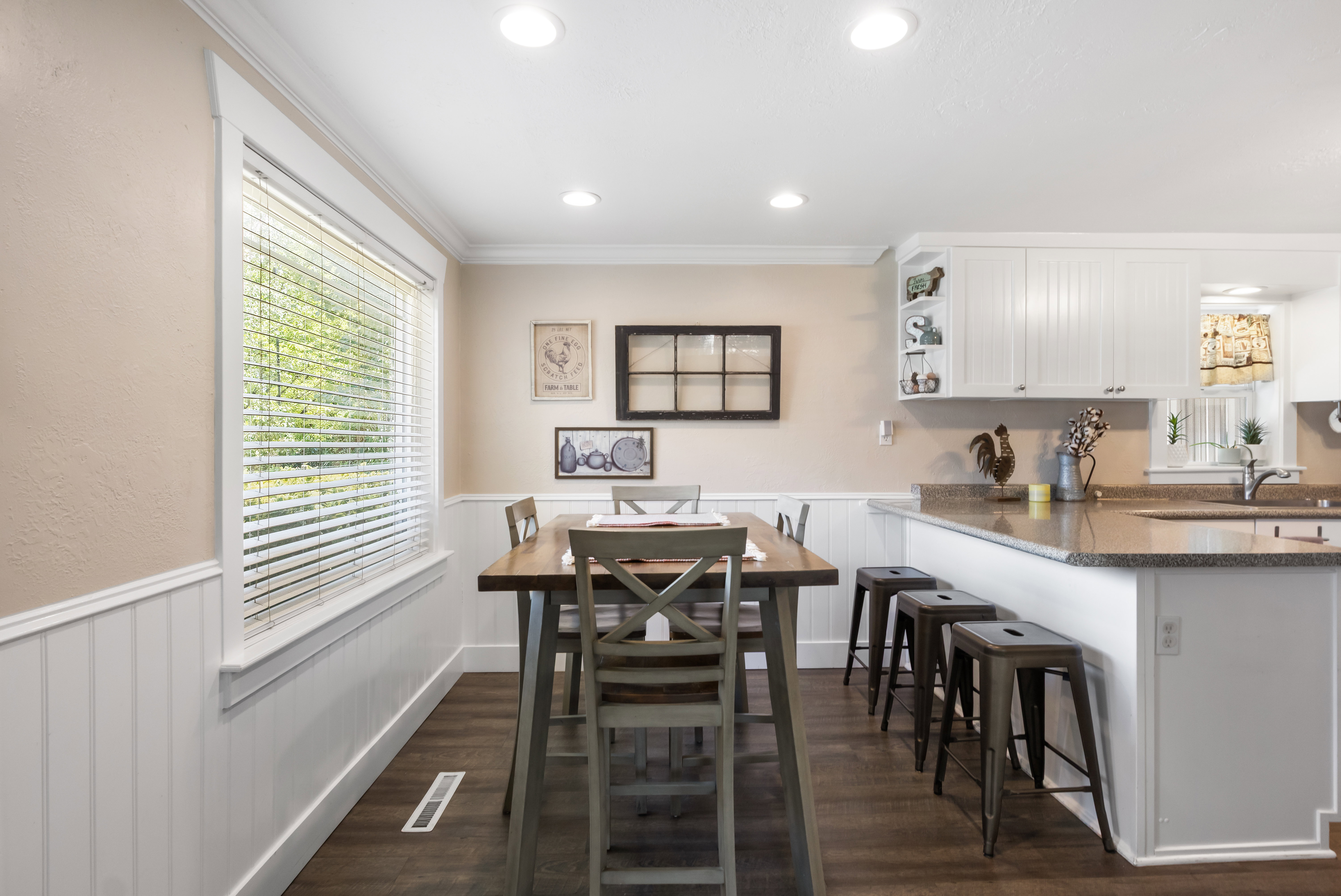 Dining area featuring wood-finish flooring, white wainscoting, and recessed lighting