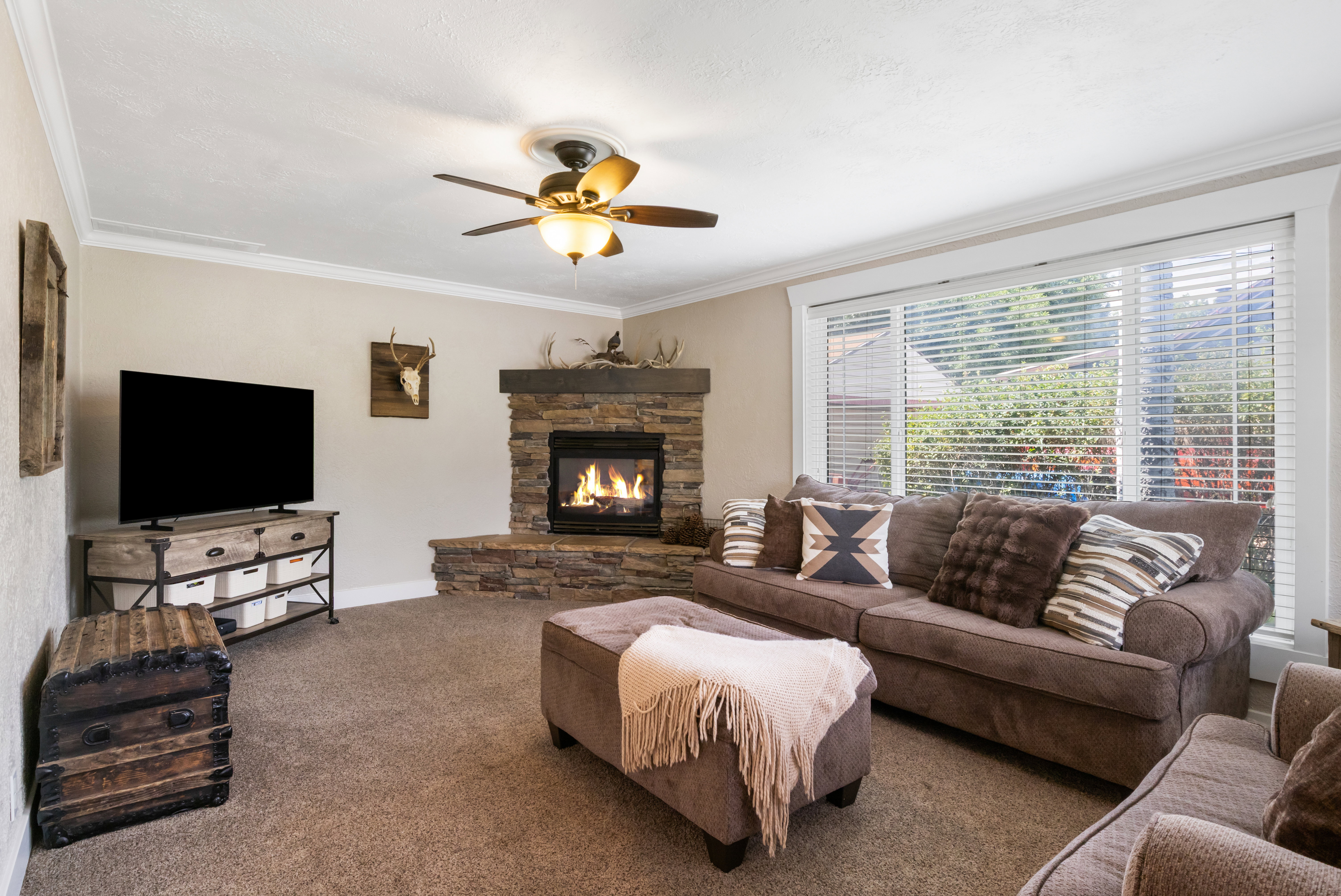 Corner fireplace featuring a stone surround and hearth, complemented by a wood mantel