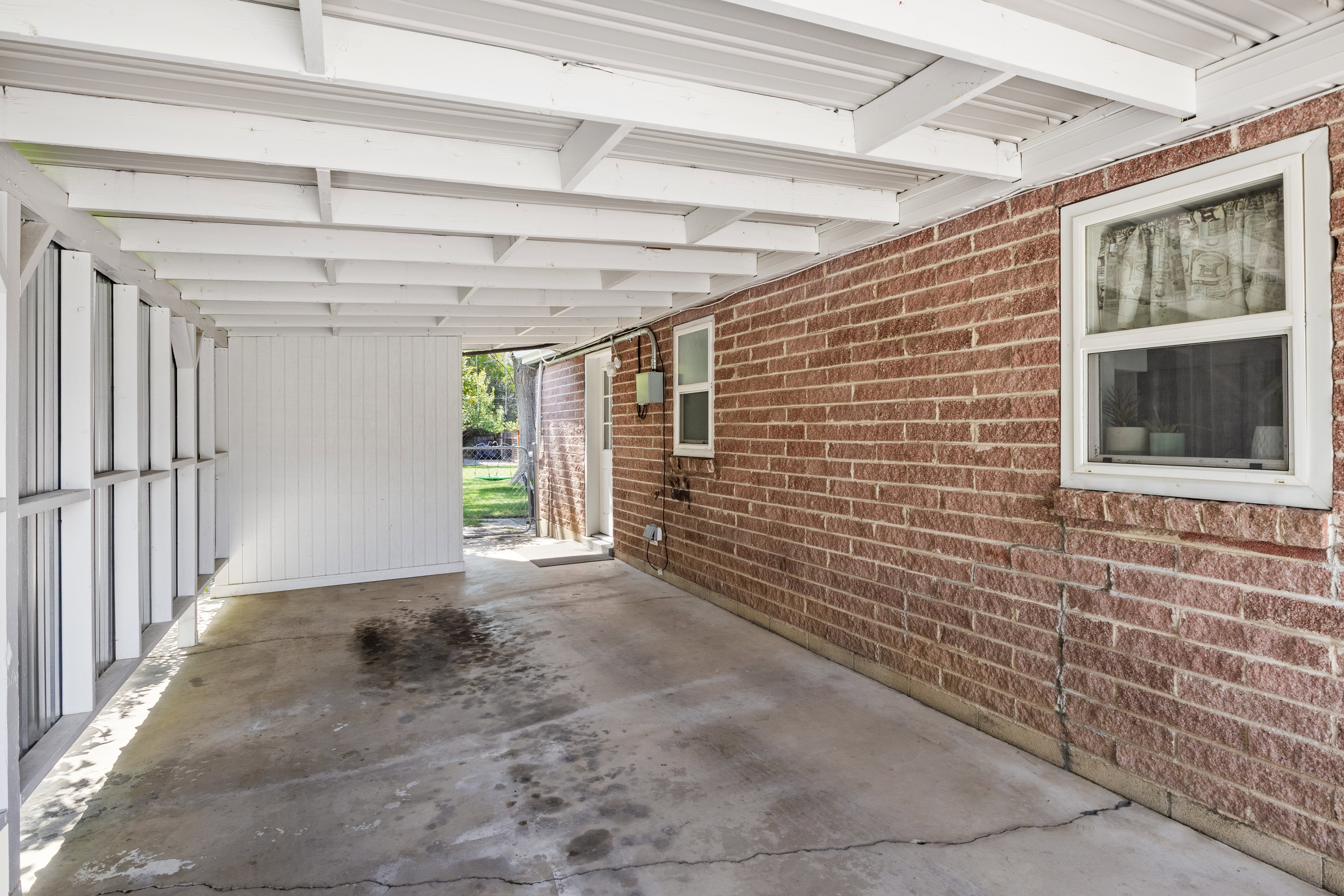 Covered patio with a concrete floor, featuring an exposed beam ceiling structure