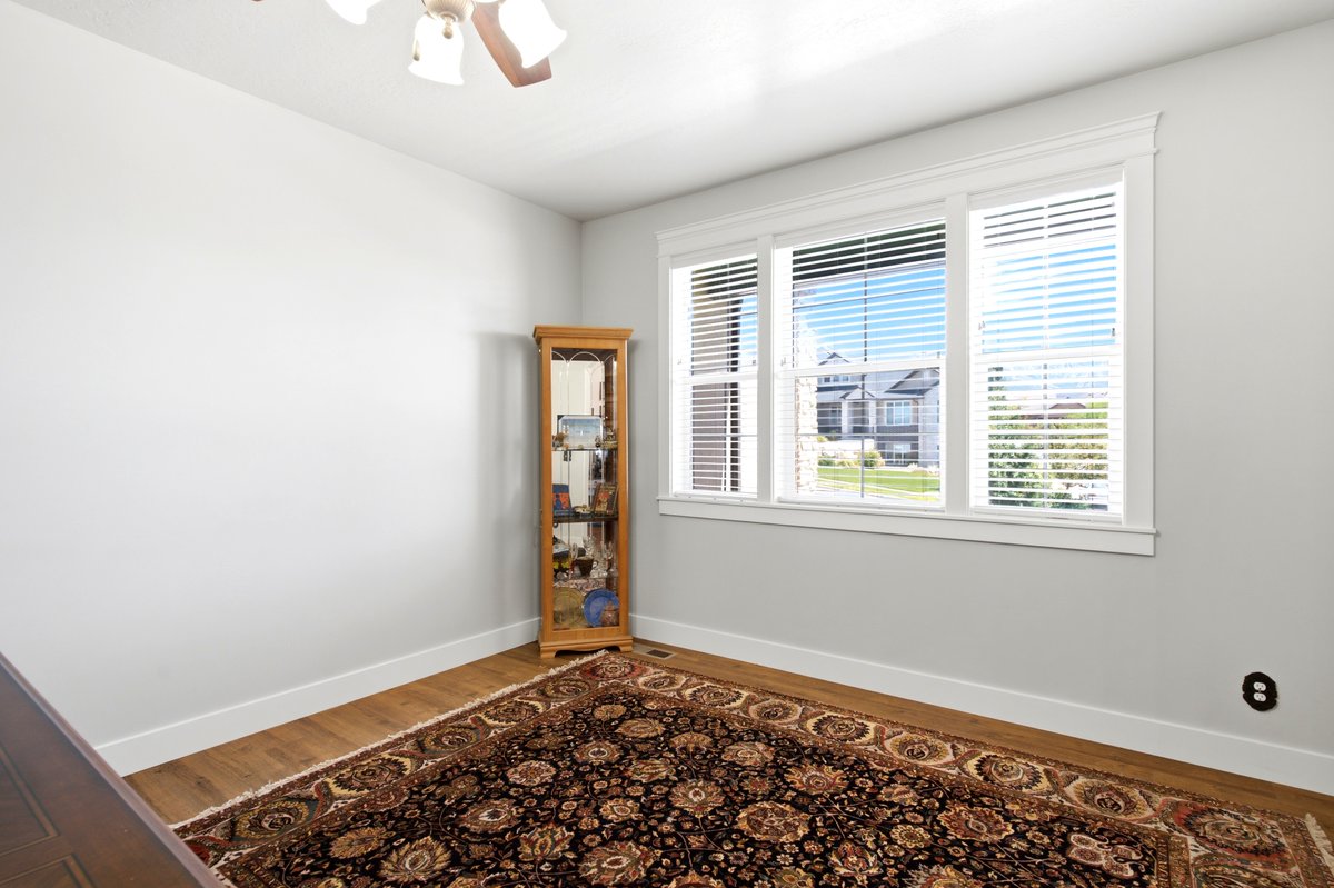 Room with light grey walls, white trim, and wood-finish flooring