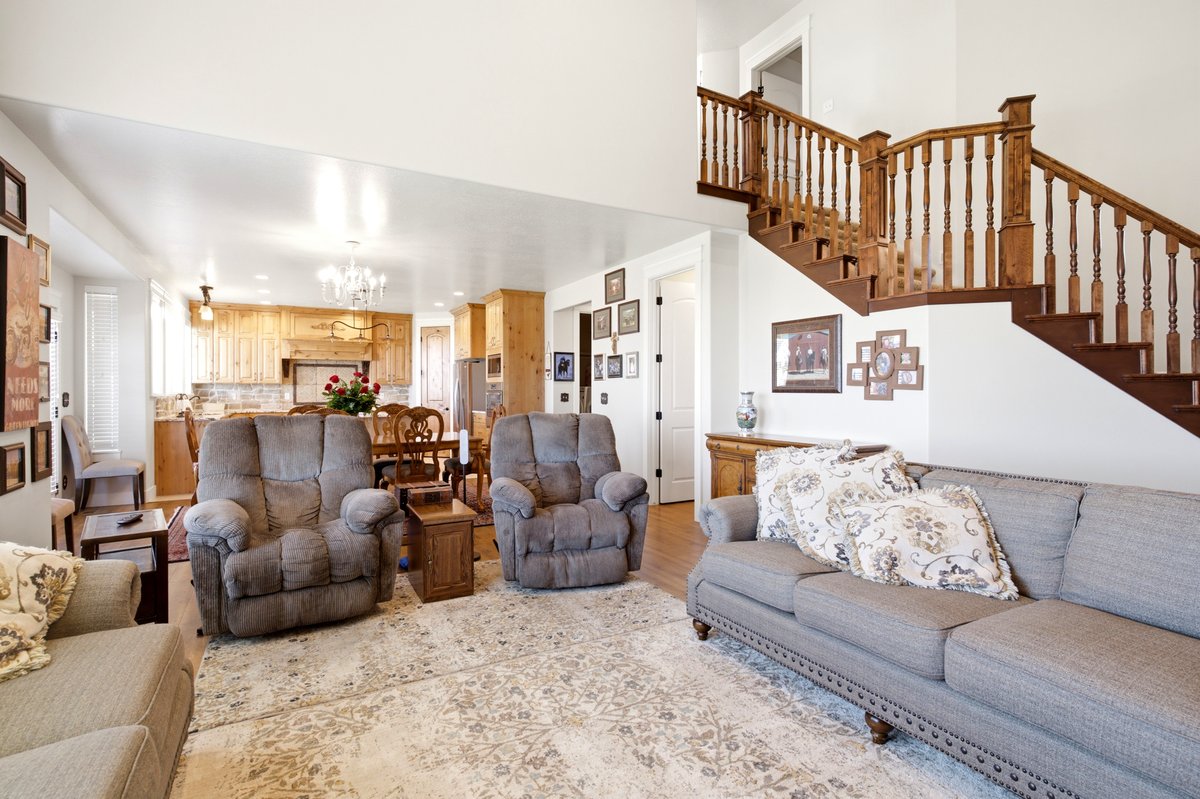 Open-concept living space featuring a wood staircase, light wood kitchen cabinetry, and light wood flooring