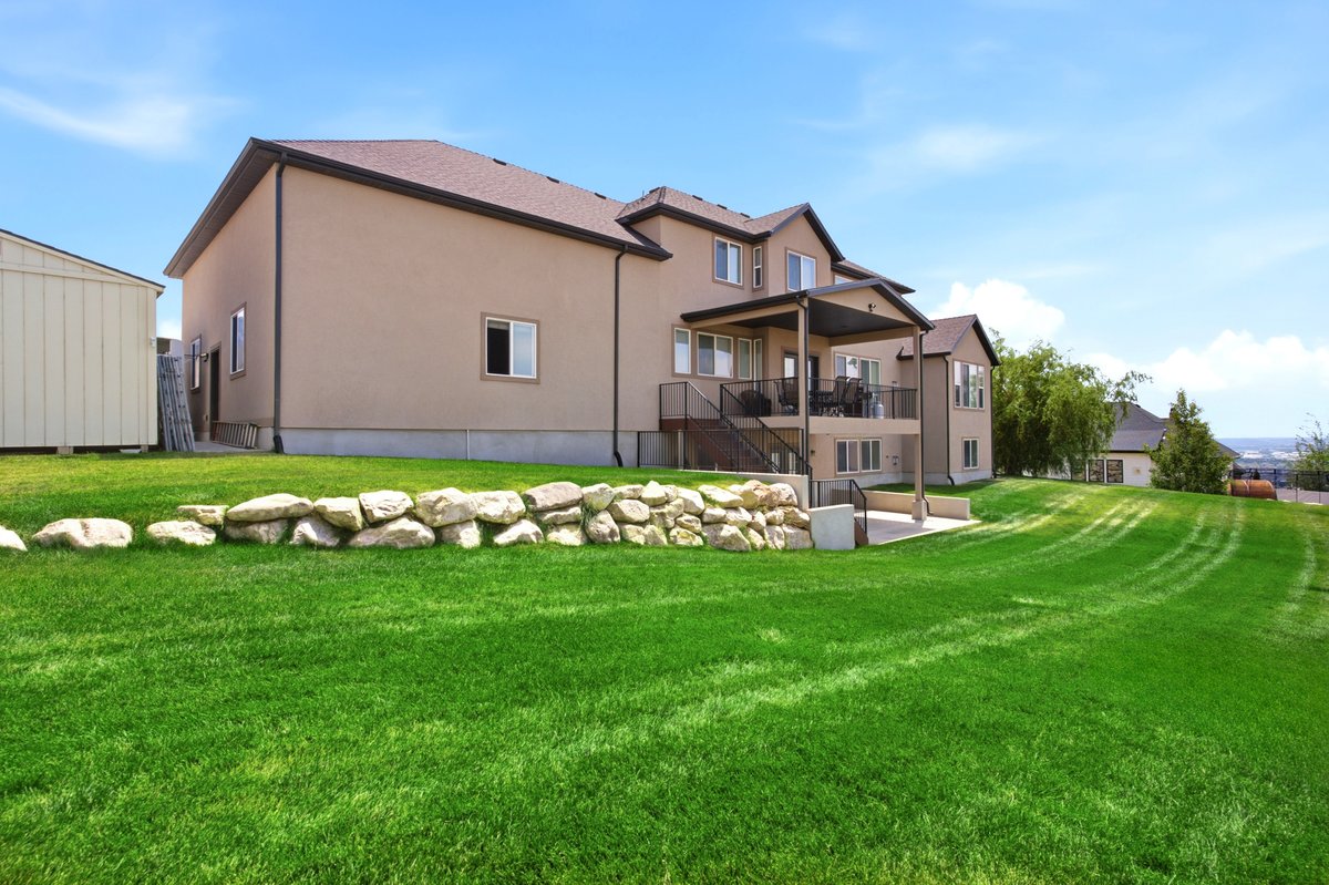 Expansive sloped lawn with a rock retaining wall