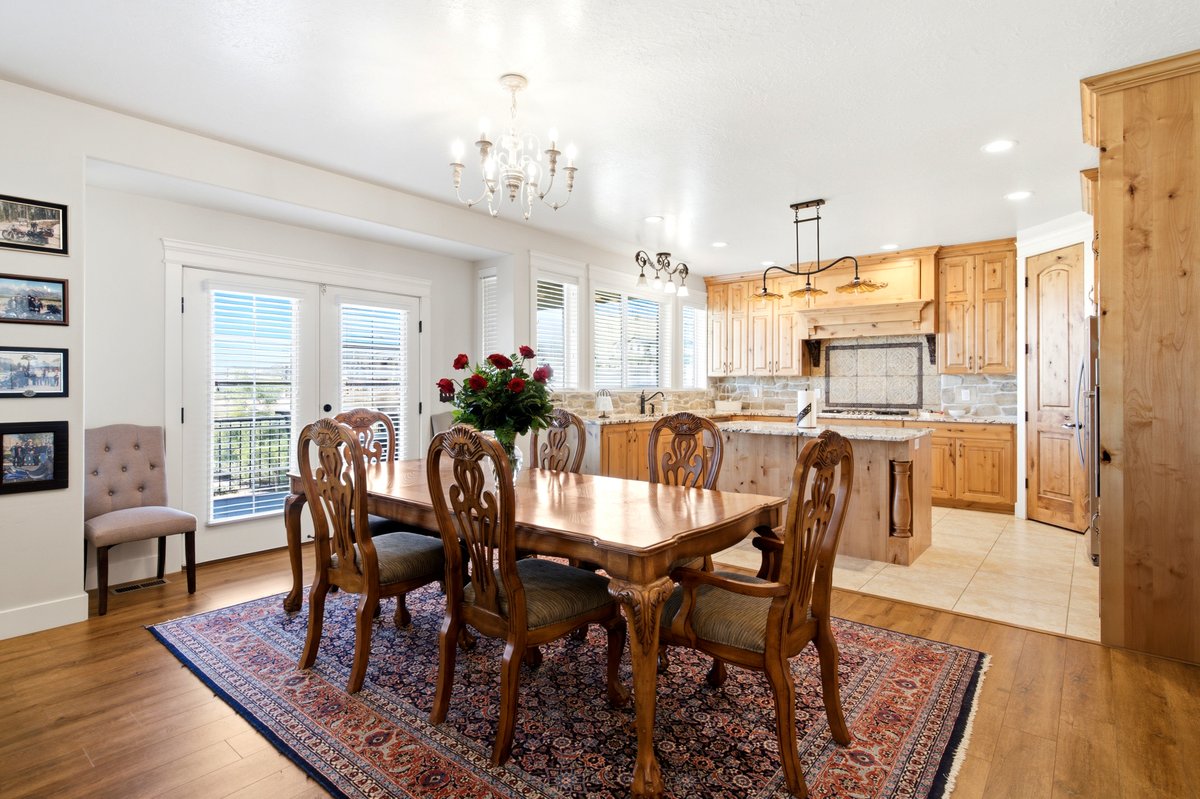 Open-concept living space featuring wood-finish flooring, a kitchen with light wood cabinetry, a central island, and a tiled backsplash
