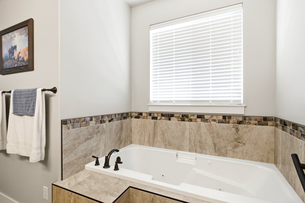 White built-in soaking tub with dark bronze fixtures