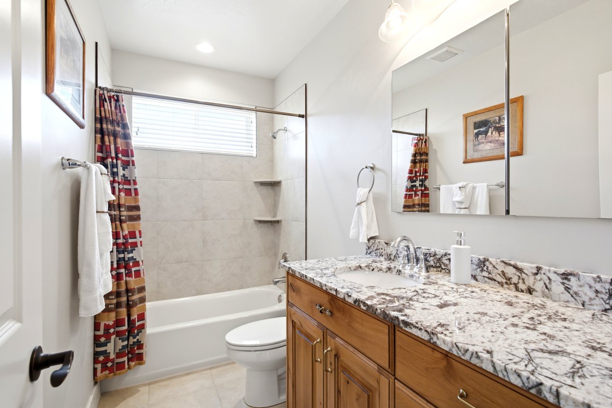 Bathroom featuring a vanity with a light-toned stone countertop, integrated sink, and wood cabinetry