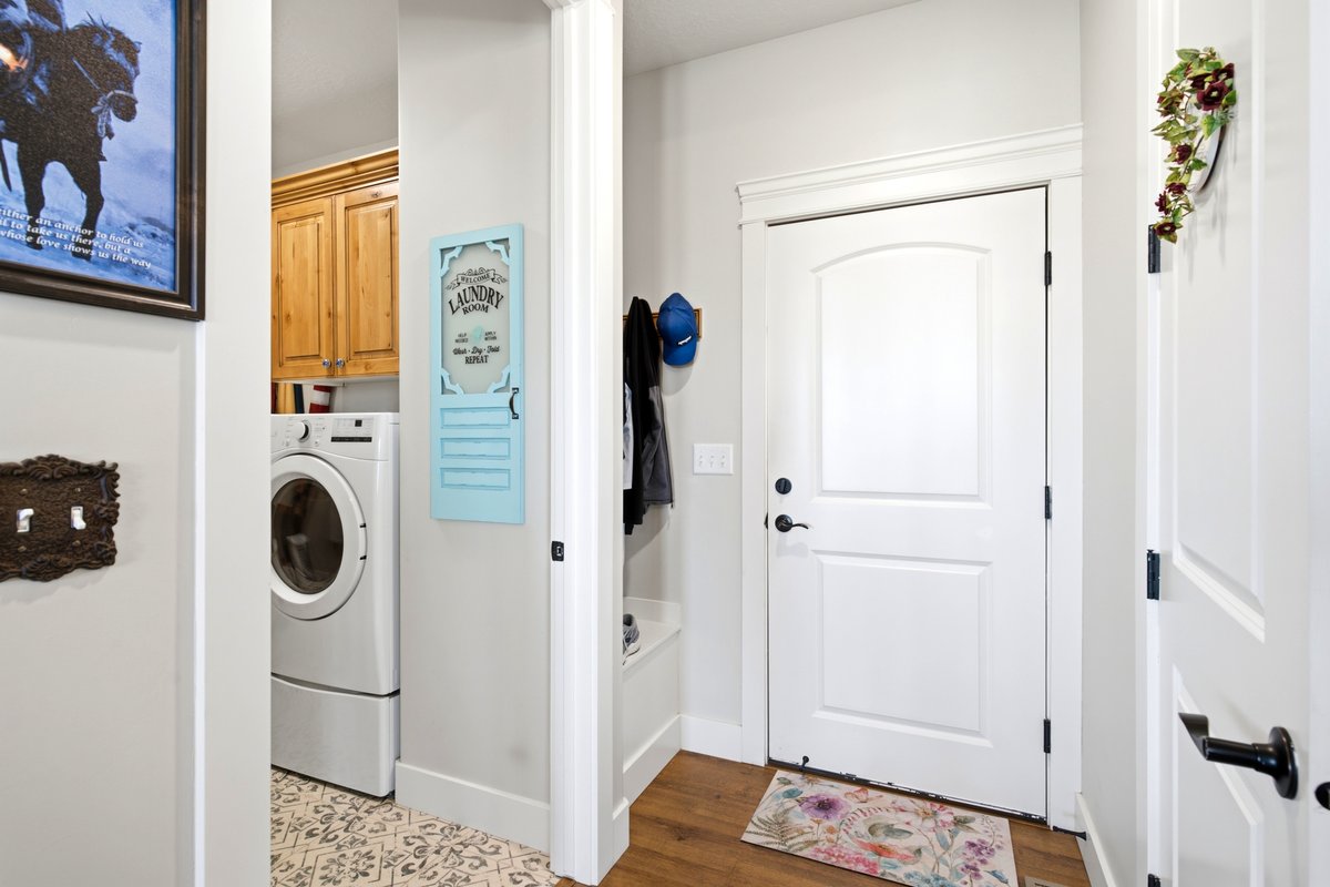 Entryway featuring a paneled door with black hardware, wood-finish flooring, and white baseboards