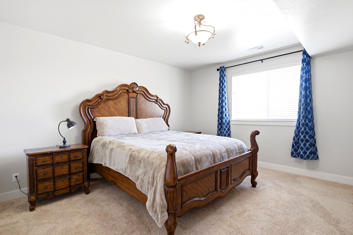 Carpeted room featuring a ceiling-mounted light fixture, white walls, and a window with blinds