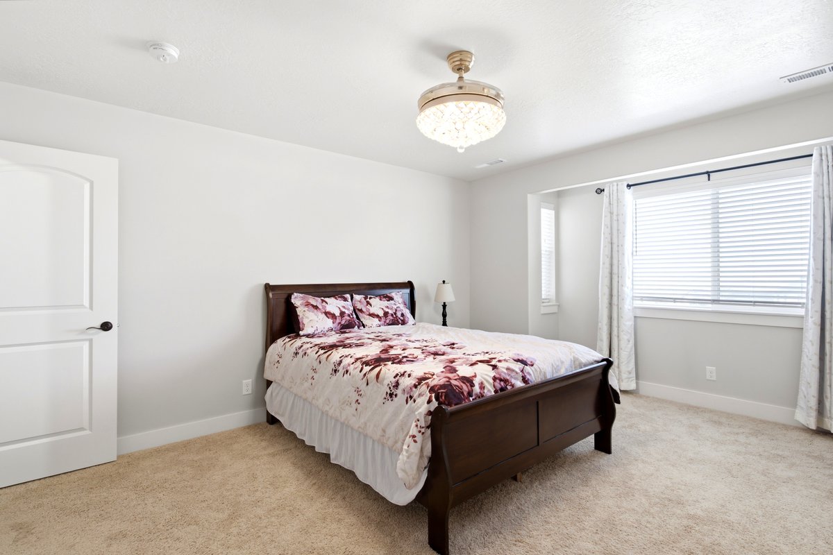 Carpeted bedroom with a decorative ceiling light fixture