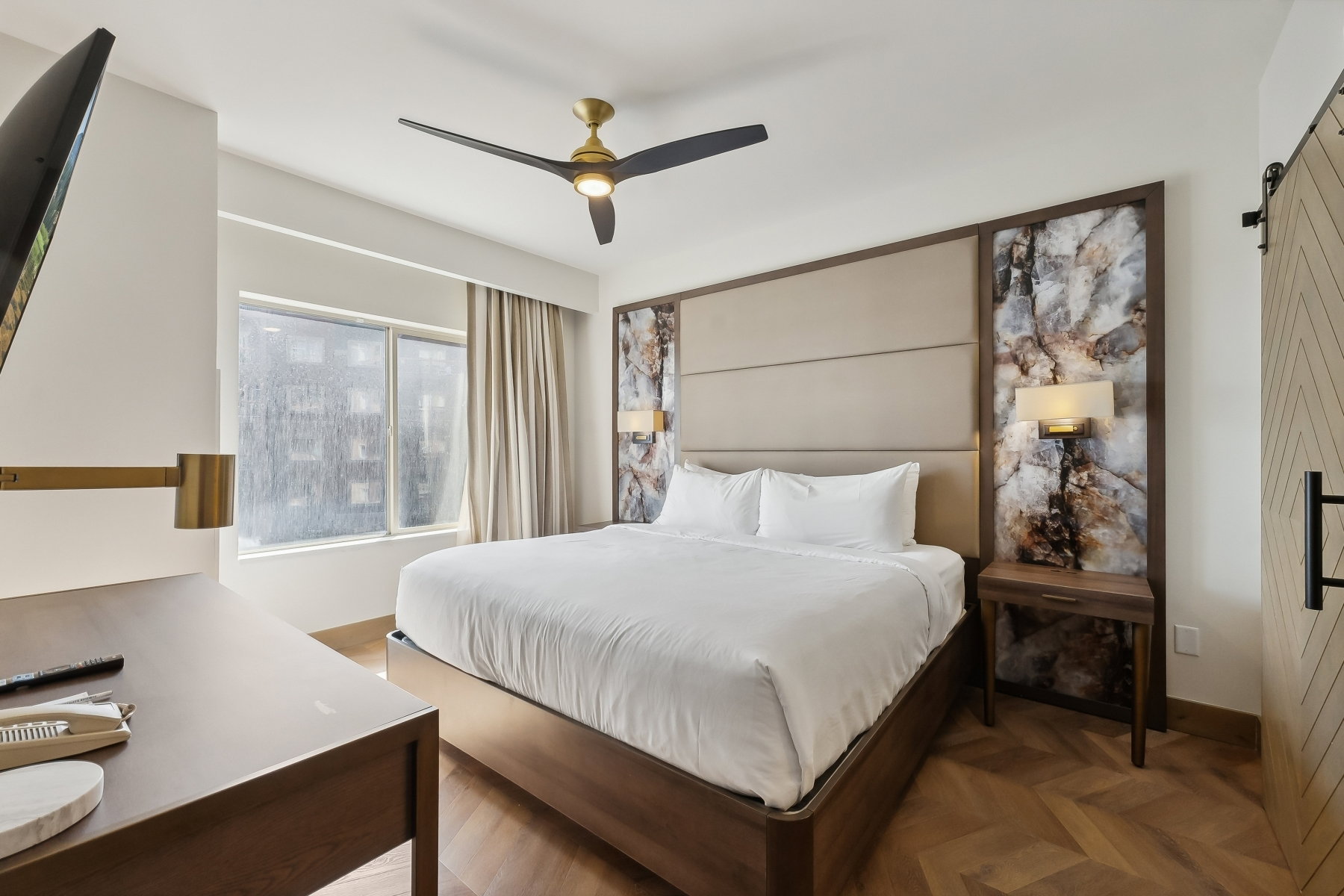 Herringbone wood-finish flooring provides a refined foundation for this space
