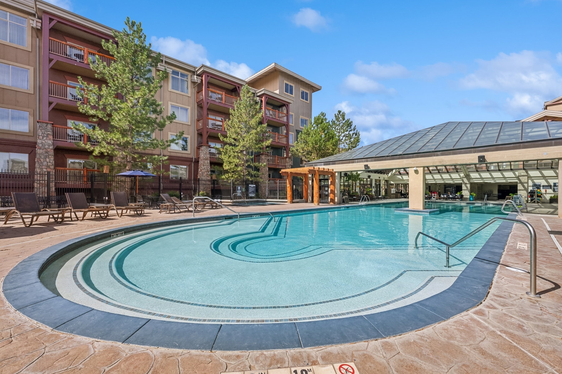 Swimming pool featuring integrated steps and a structured patio surround