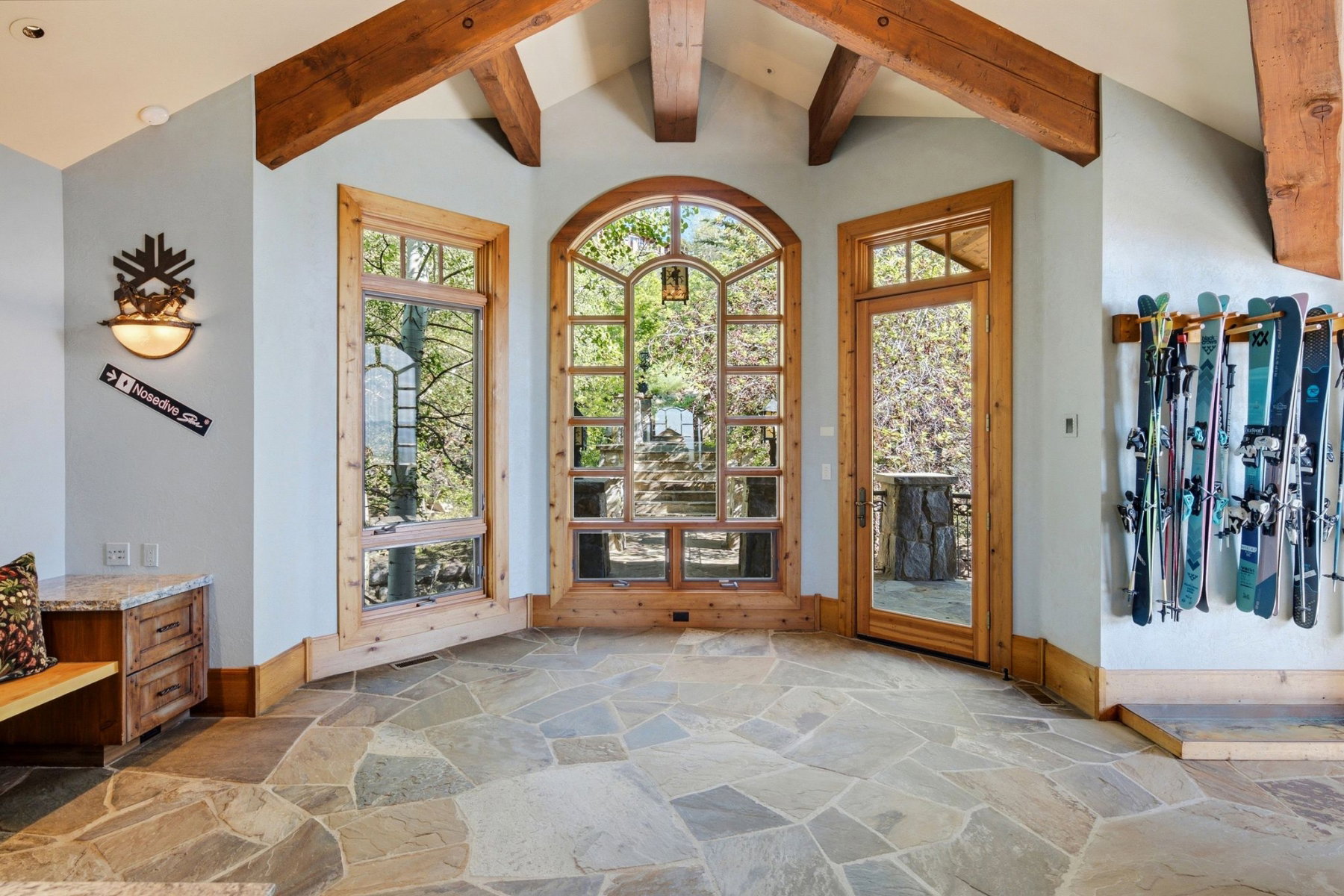 Vaulted ceilings with exposed timber beams complement the irregular flagstone flooring