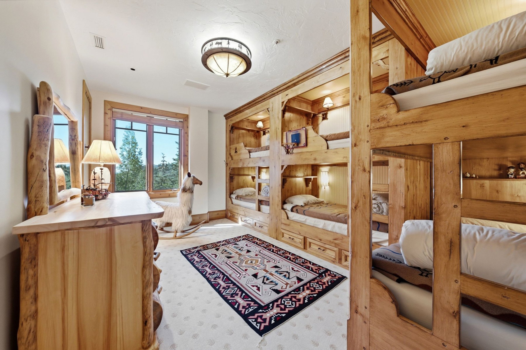 Room featuring built-in wooden bunk beds with individual lighting and storage drawers