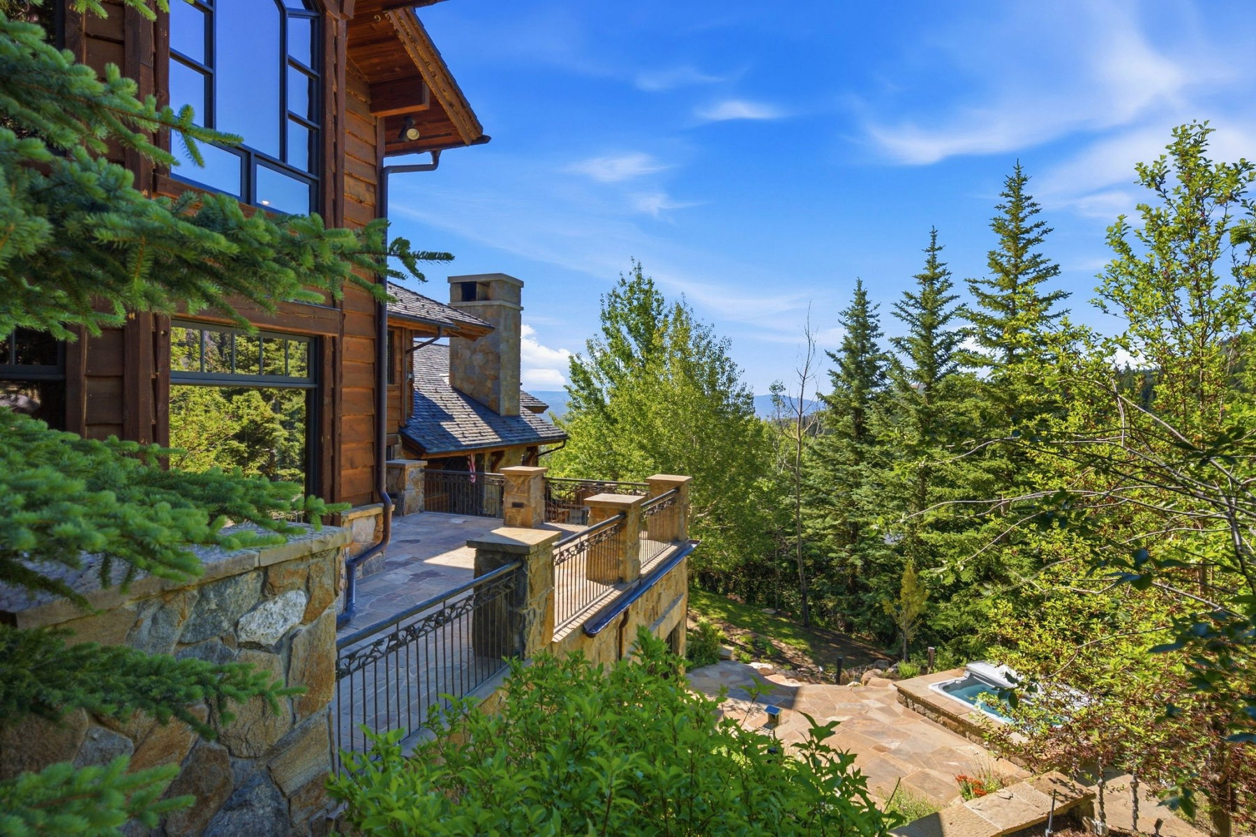 Multi-level outdoor patio with stone retaining walls and ornate metal railings