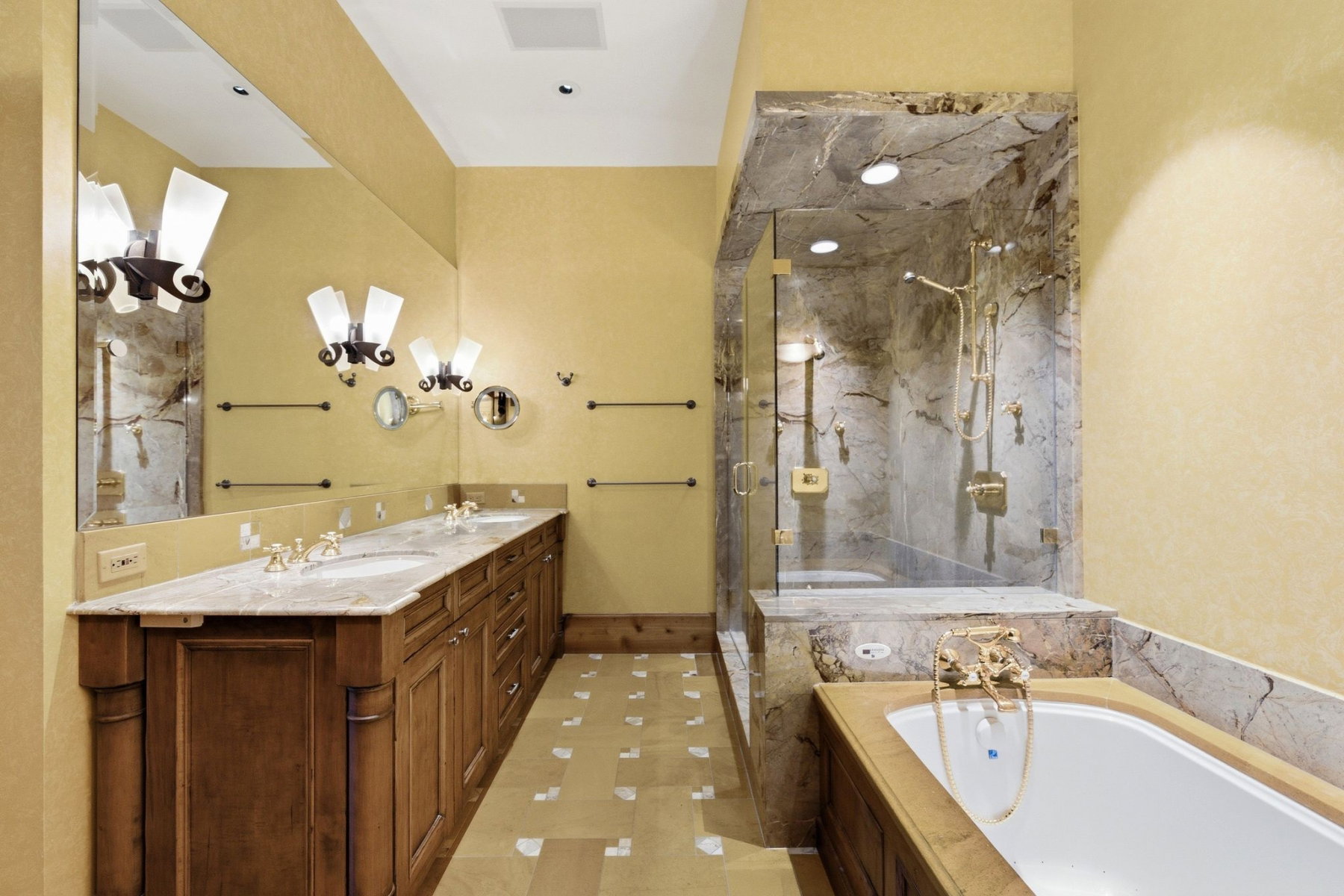 Bathroom featuring a dual vanity with a light-toned countertop, a built-in tub, and a glass-enclosed shower with a multi-jet system