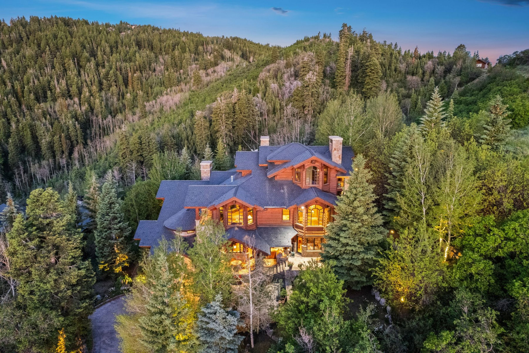 Expansive multi-level residence featuring rustic wood siding and a dark shingle roof