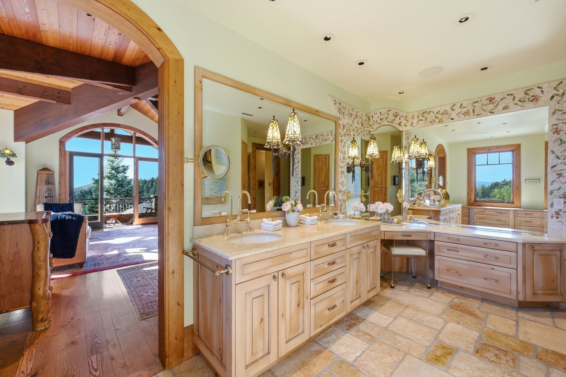 Dual vanity with integrated sinks and brass fixtures, set into a light-toned wood-finish cabinetry