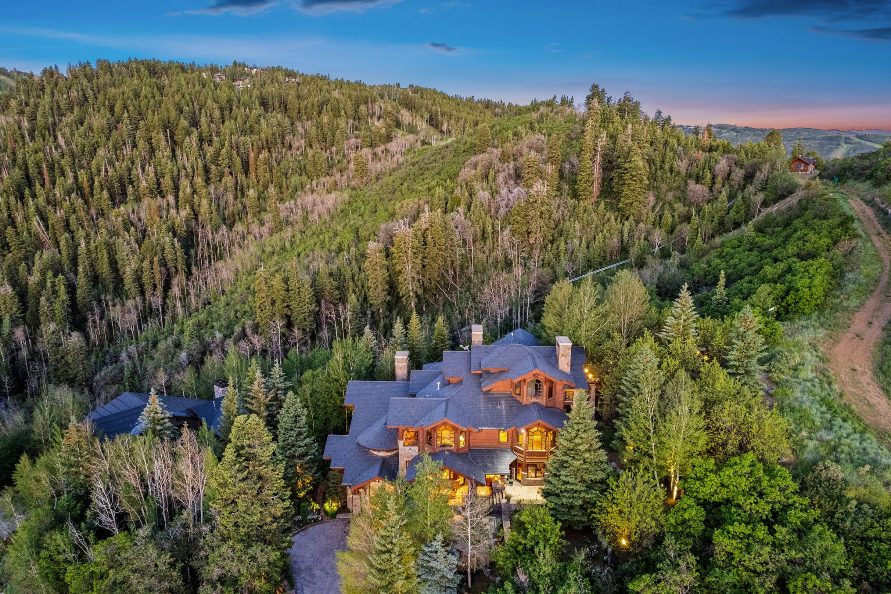 Expansive mountain estate surrounded by dense evergreen and deciduous trees