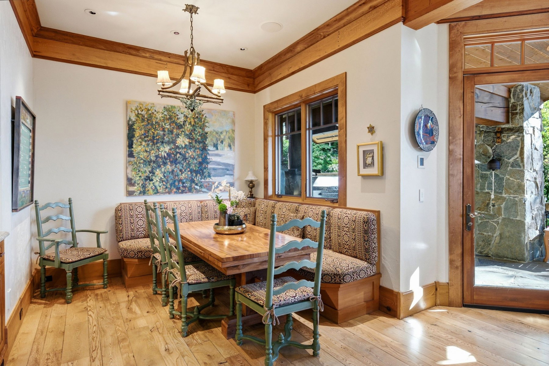 Dining space featuring wood-finish flooring, a built-in banquette, and a wood-framed window with exterior views