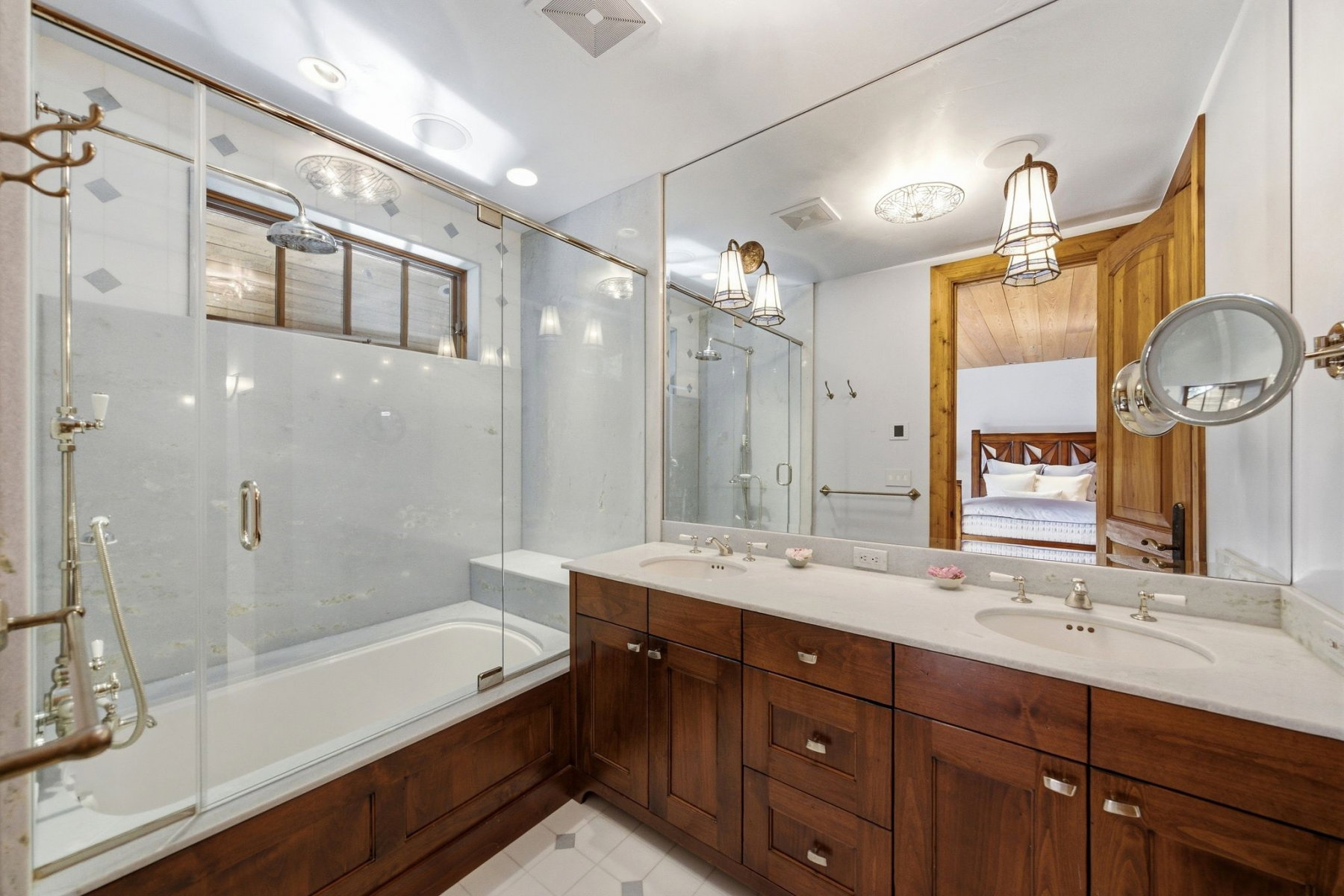 Bathroom featuring a double vanity with stone countertops, integrated sinks, and brass-tone fixtures