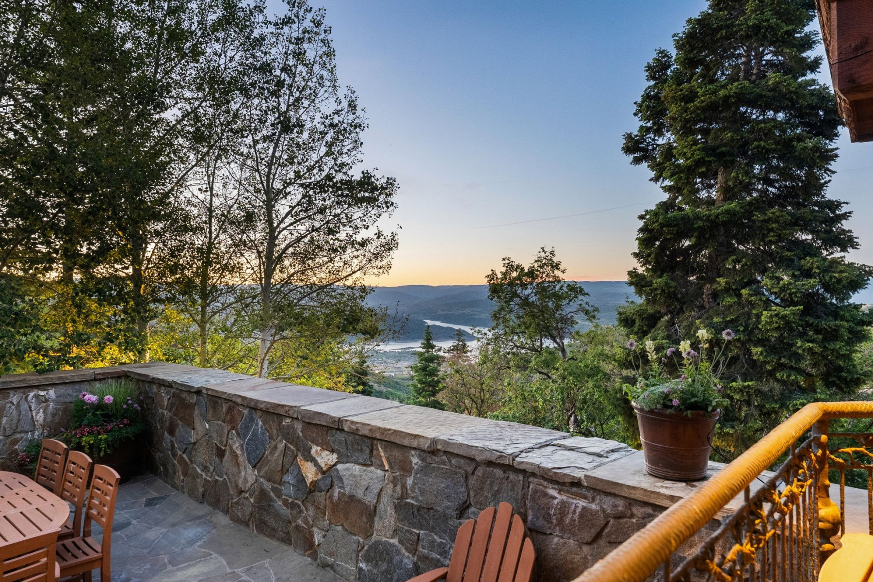 Stone-clad patio with flagstone flooring, solid stone wall, and metal railing